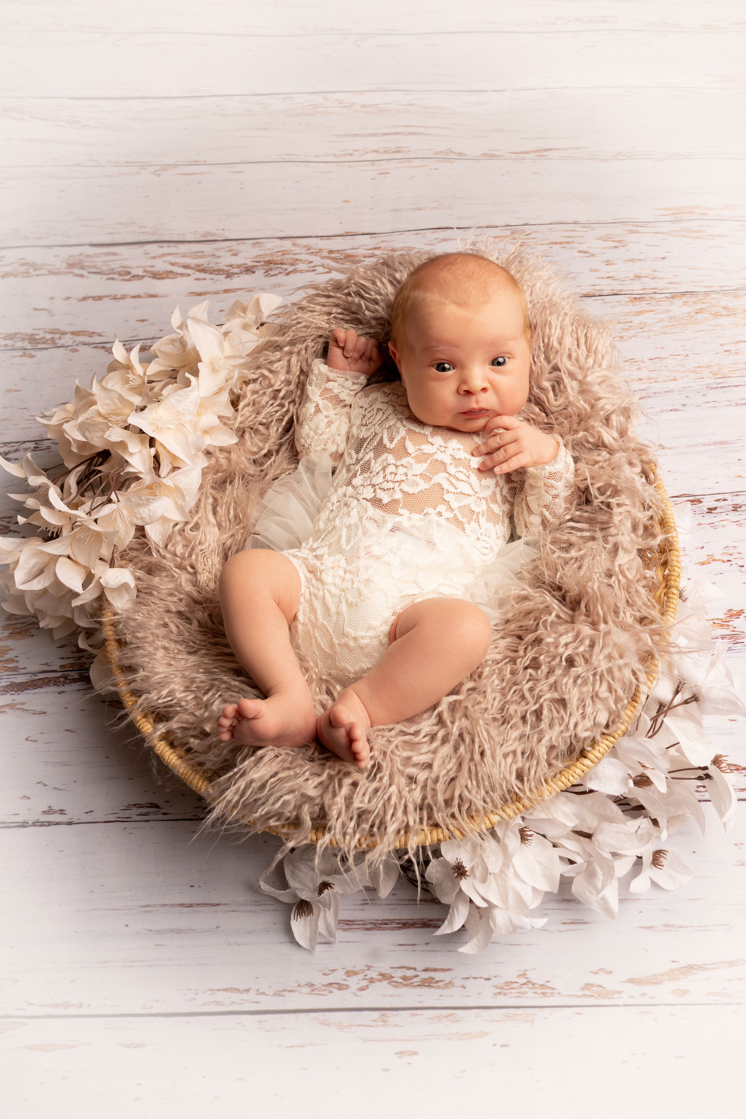 nachdenkliches und bewusstes Baby in einem milchigen Kleid