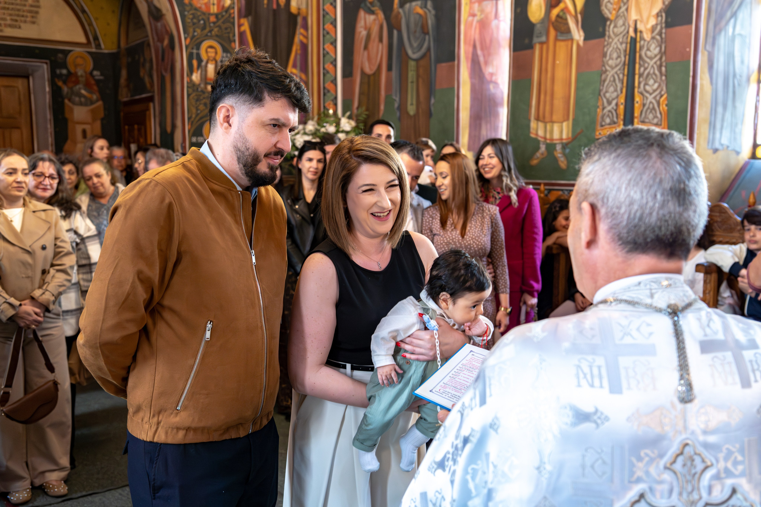 nasi cu bebelus in brate in biserica