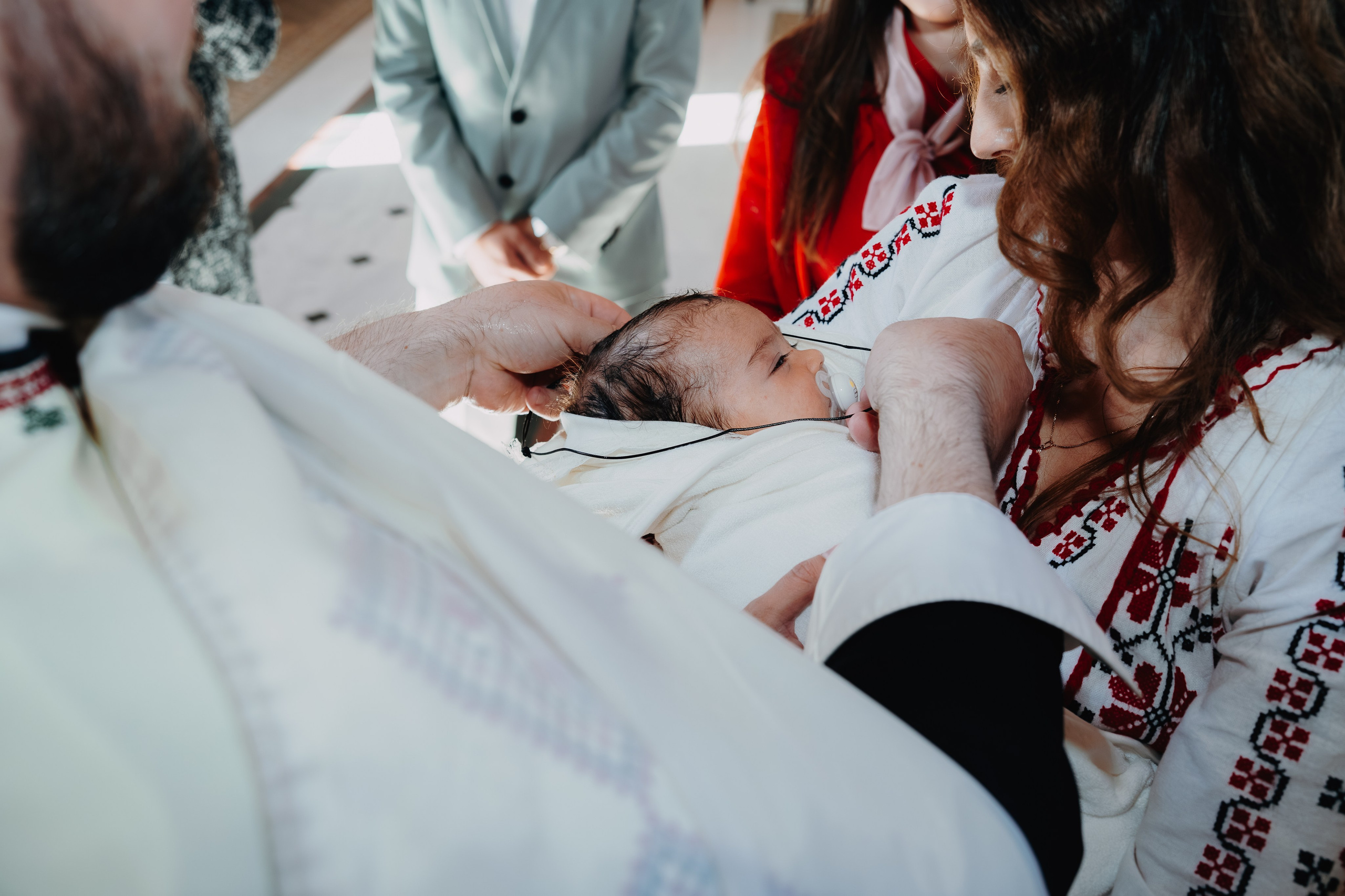 După scăldarea botezului, Arthur Mihail este predat în brațele nașei, care îl aștepta cu un prosop alb și curat. Un moment de grijă și tandrețe care urmează imediat după taina sfântă.