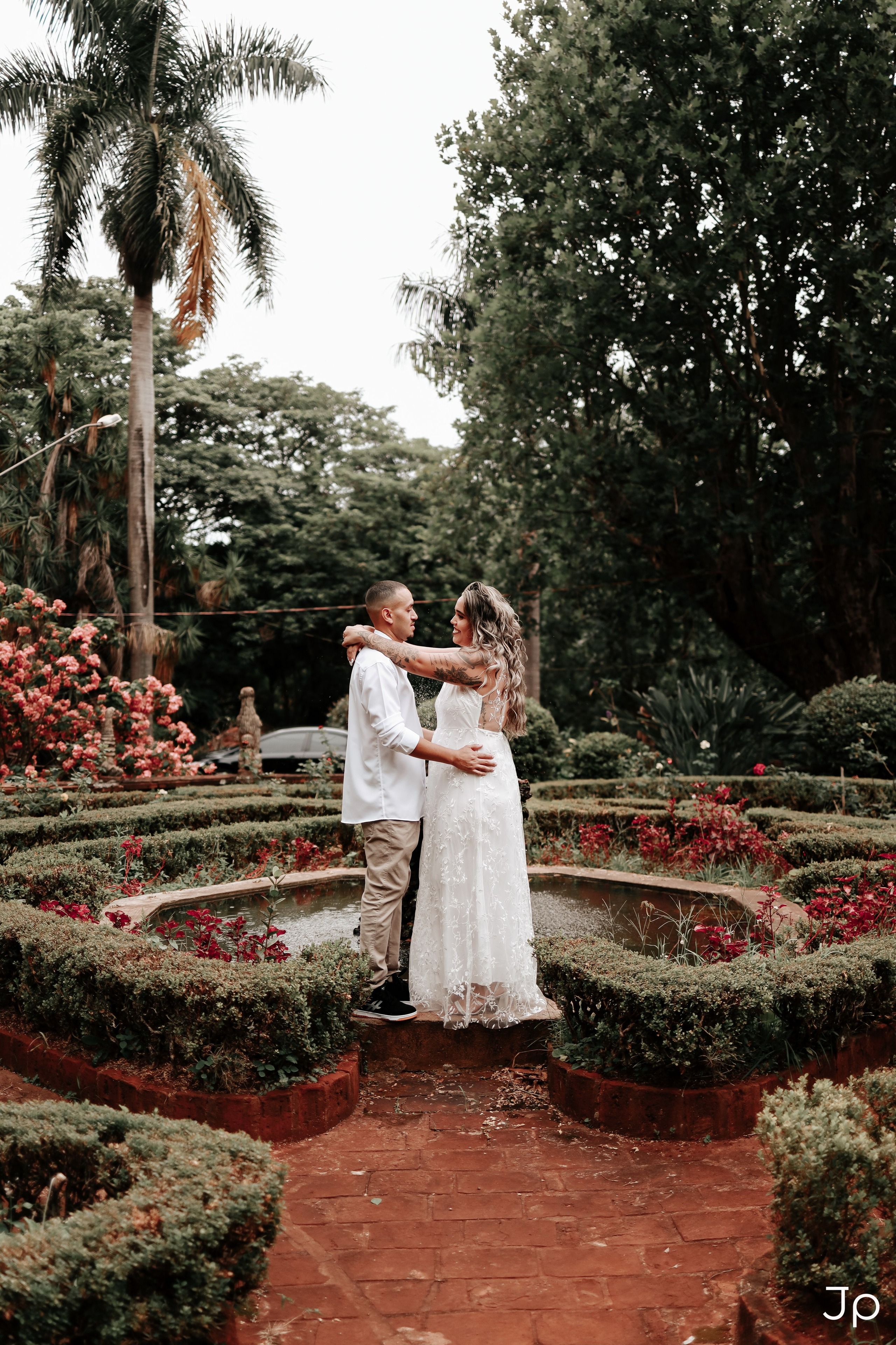 Ensaio pré-wedding em Pederneiras com casal abraçado no caminho de pedras do jardim.