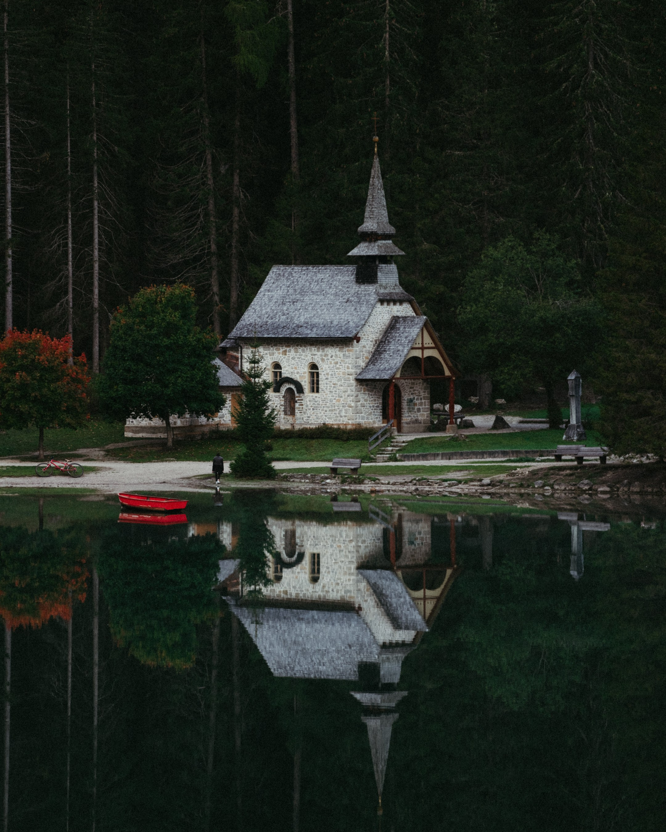A church next to a lake and forrest in Italian dolomites 