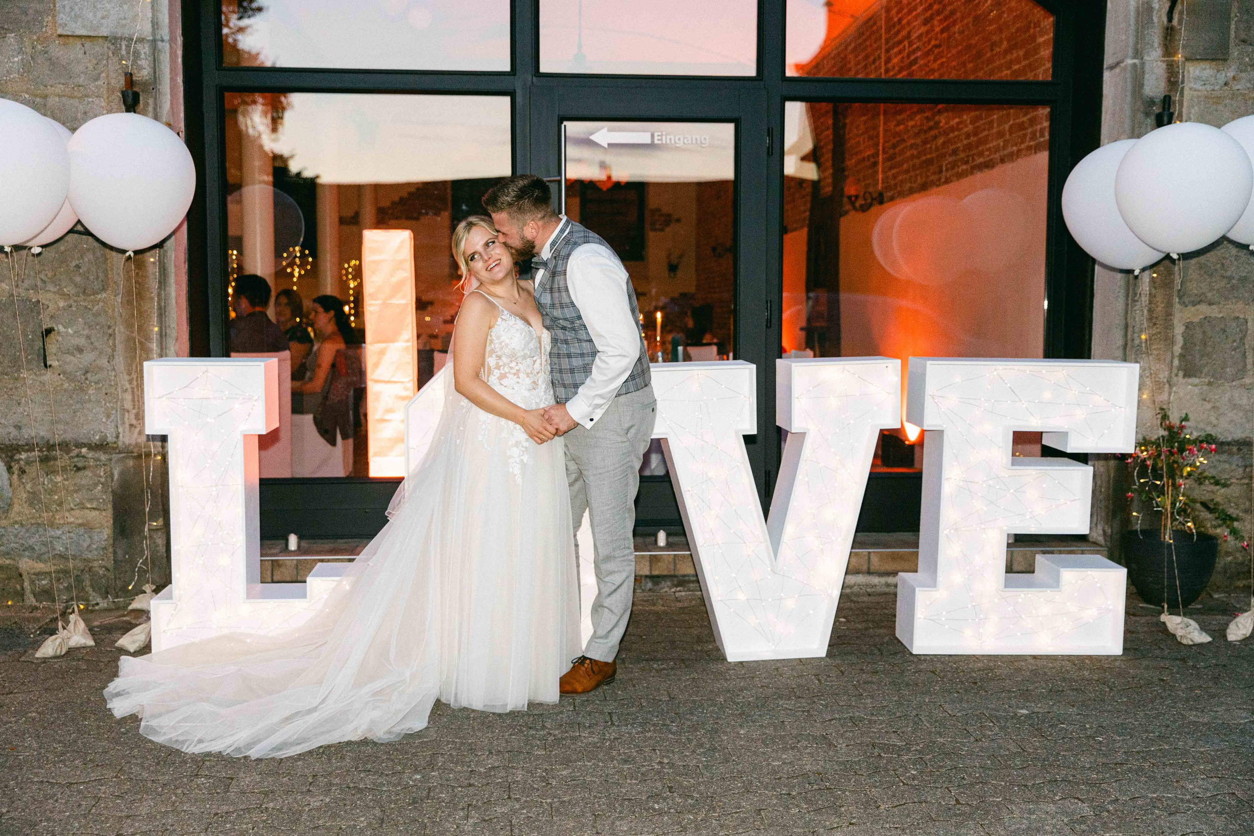 Brautpaar bei ihrer Hochzeit im Rittergut Voldagsen vor love buchstaben