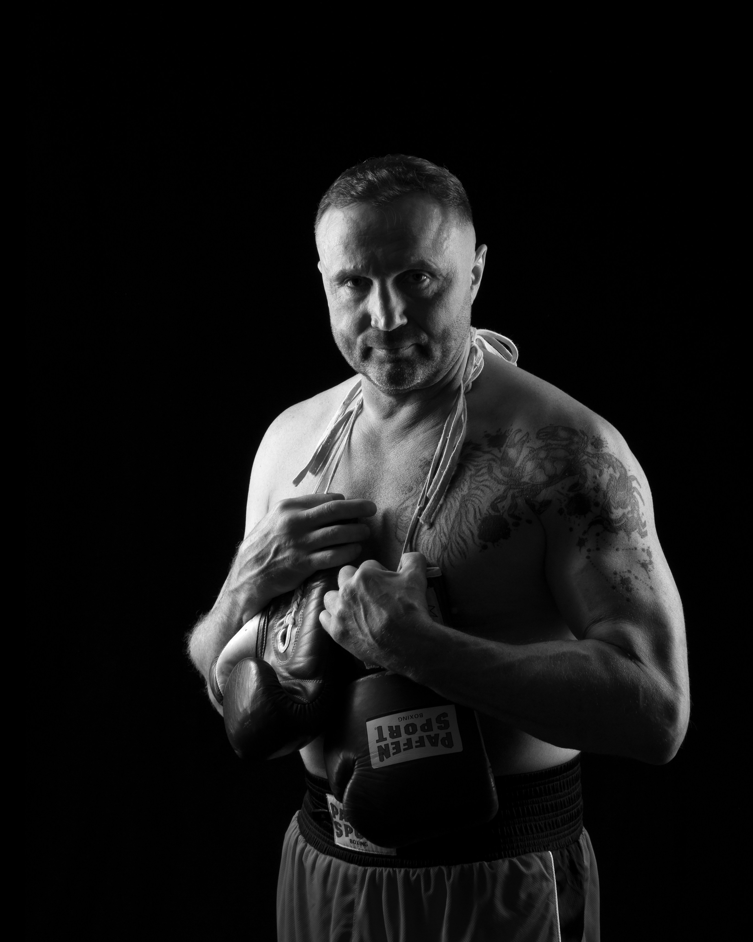 Stilvolles Portrait eines Boxers – Vitalii, betont durch dramatisches Konturlicht