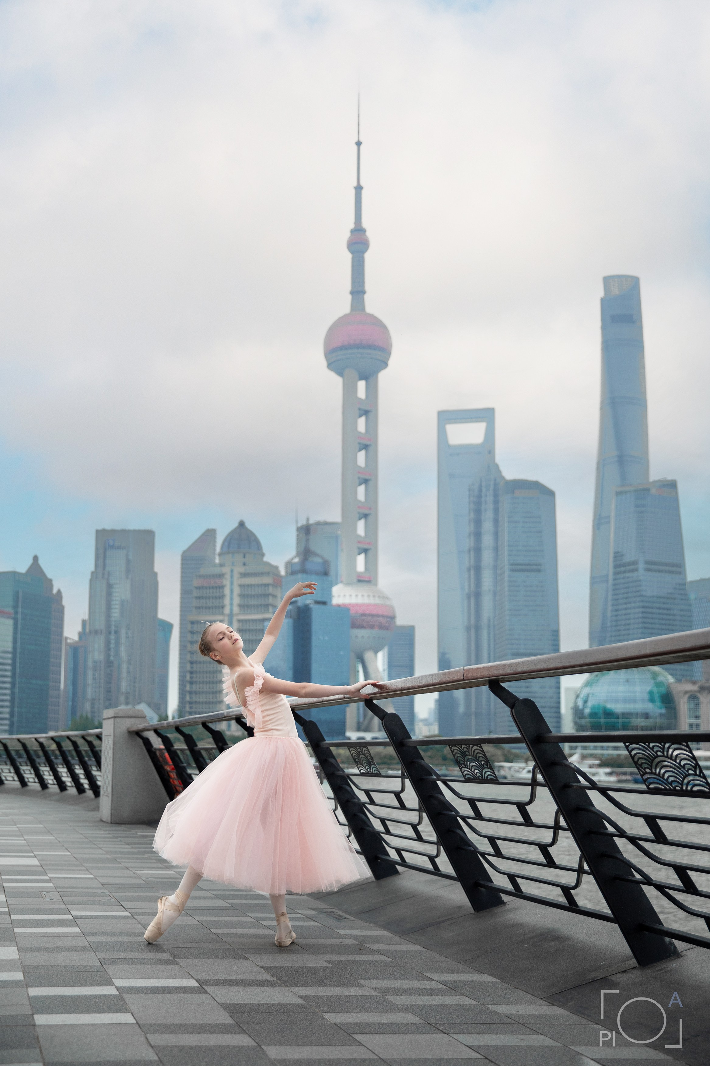 Фотосессия в Шанхае для девочки 11 лет. Маленькая балерина в розовом платье с пышной длинной пачкой, танцует на набережной в Шанхае с видом на Lujiazui