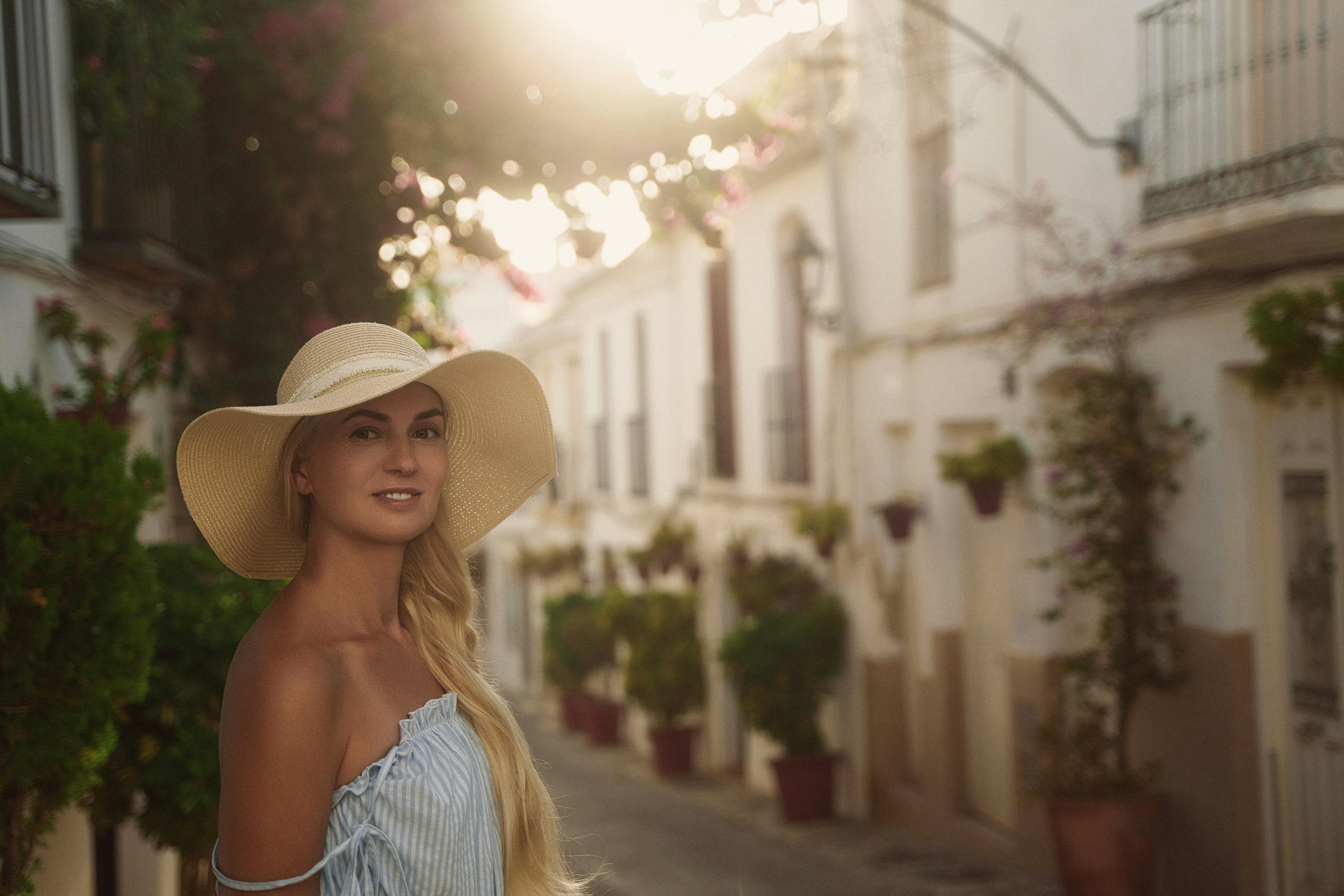 Chic blonde model posing gracefully in Estepona charming old town streets