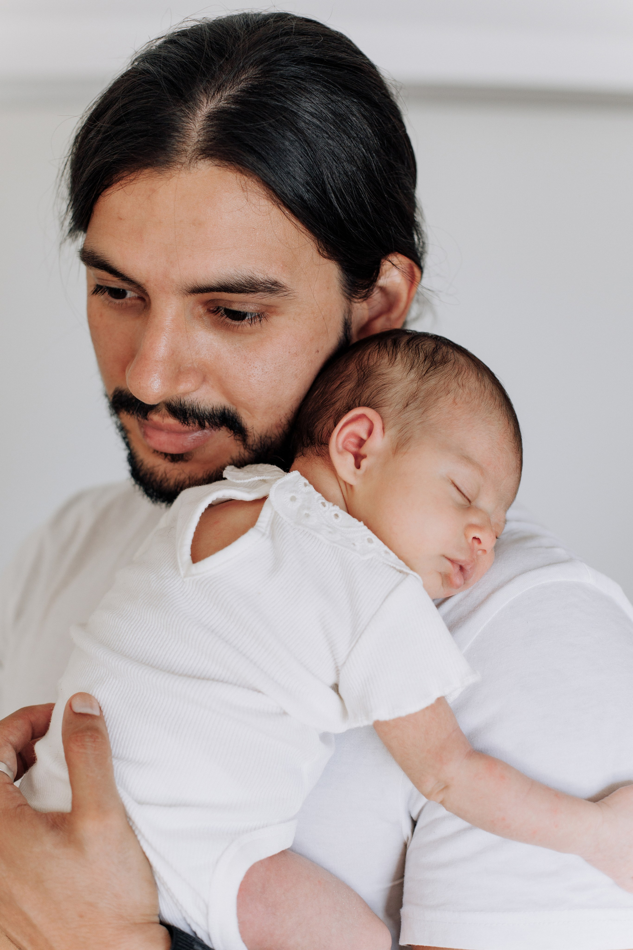 Vater umarmt seine neugeborene Tochter liebevoll.