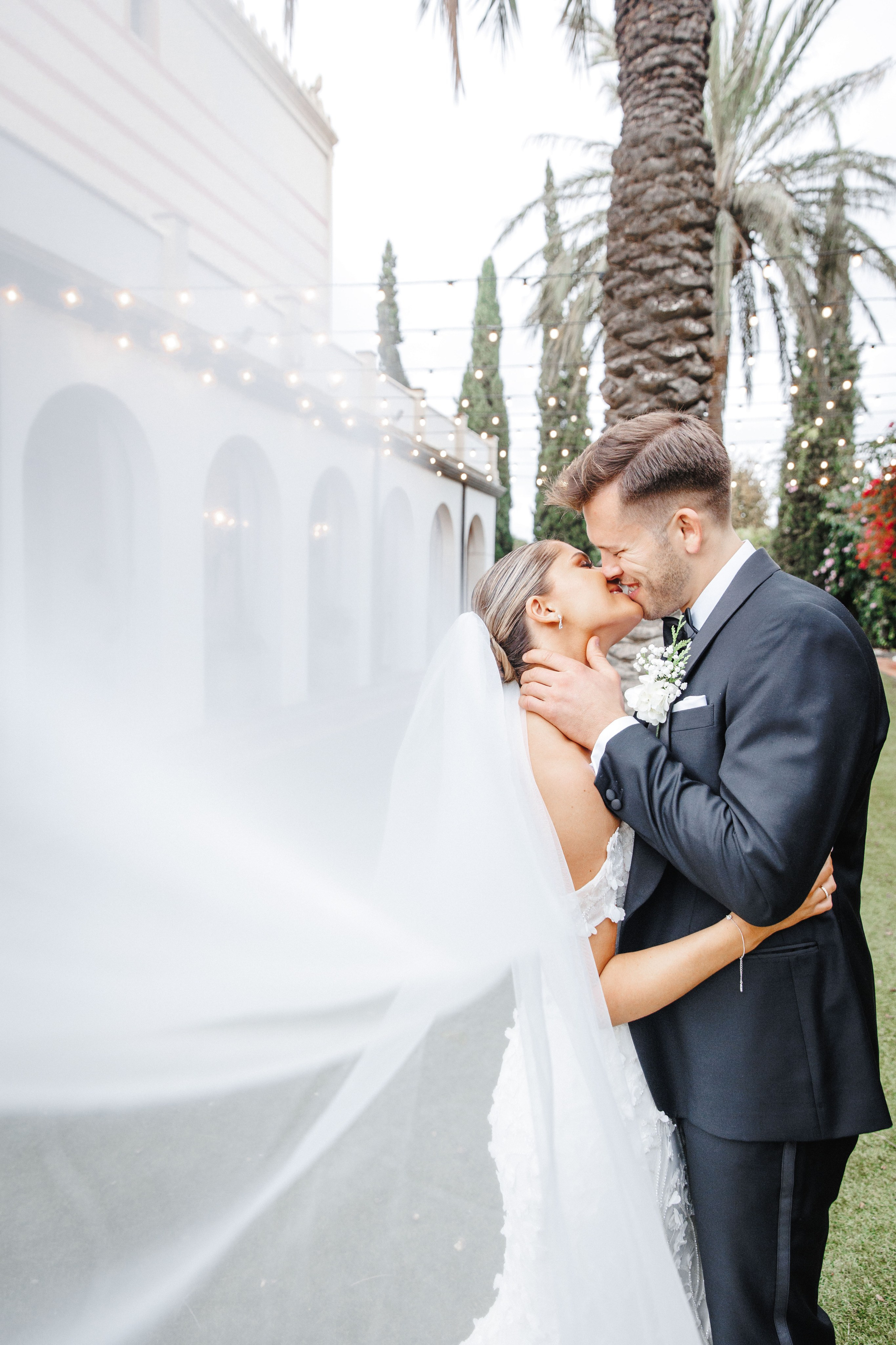 Intimate moment of the bride and groom sharing a kiss during their wedding portrait session in Barcelona.