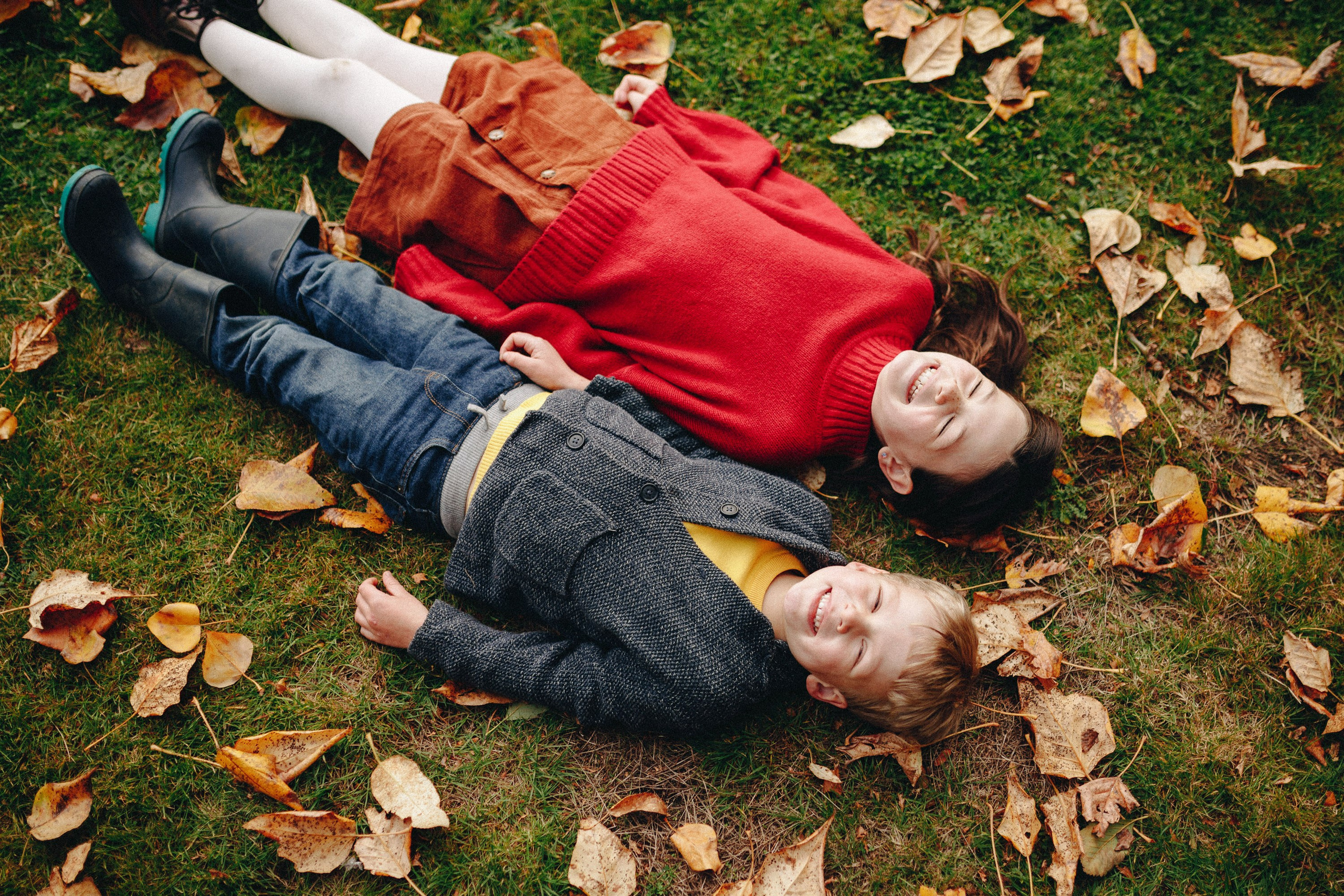 Couple lying on autumn leaves, fun and candid moment