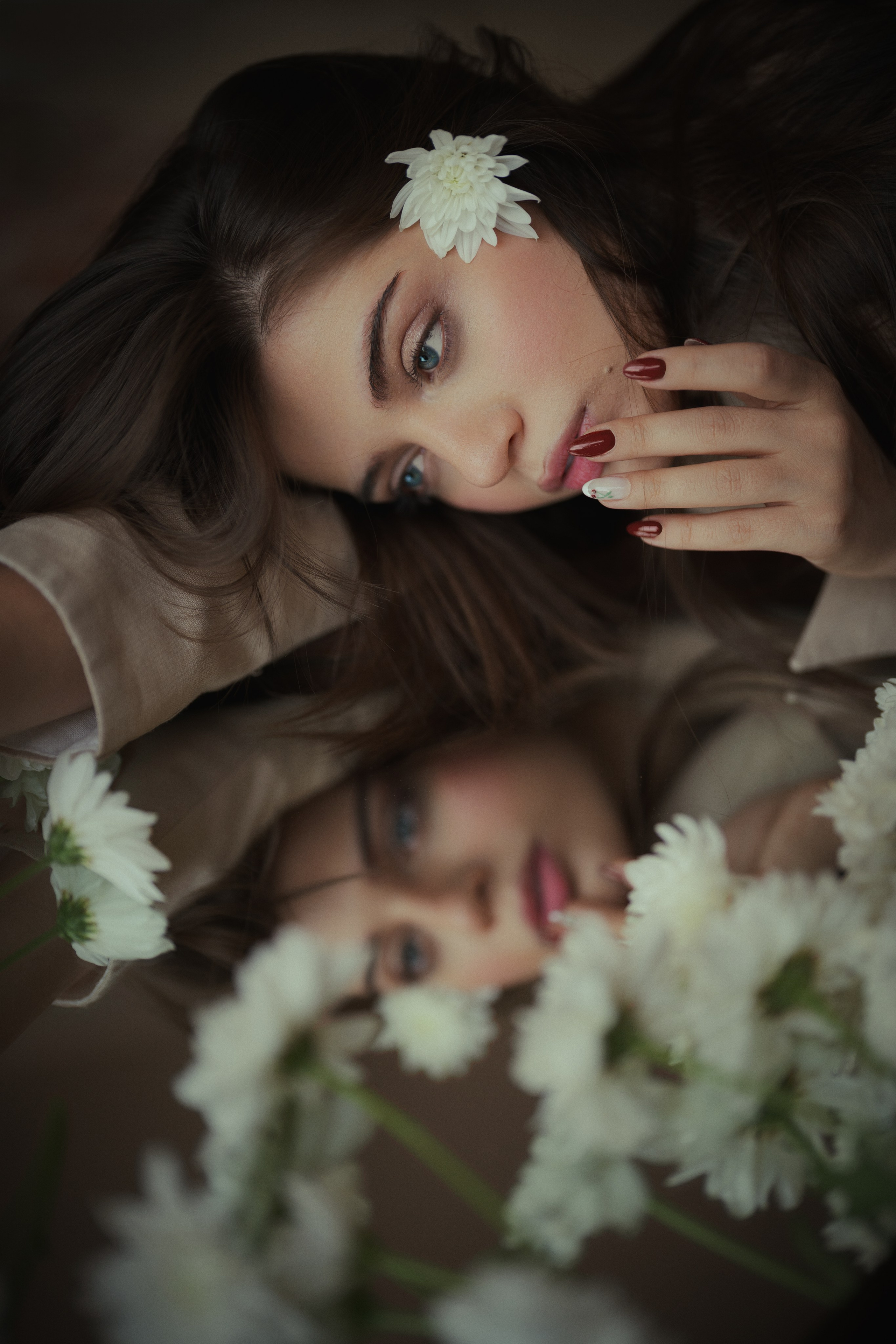 Floral beauty portrait reflected in a mirror, featuring white flowers, warm neutral tones and shallow depth of field by Mehran Hadad.
