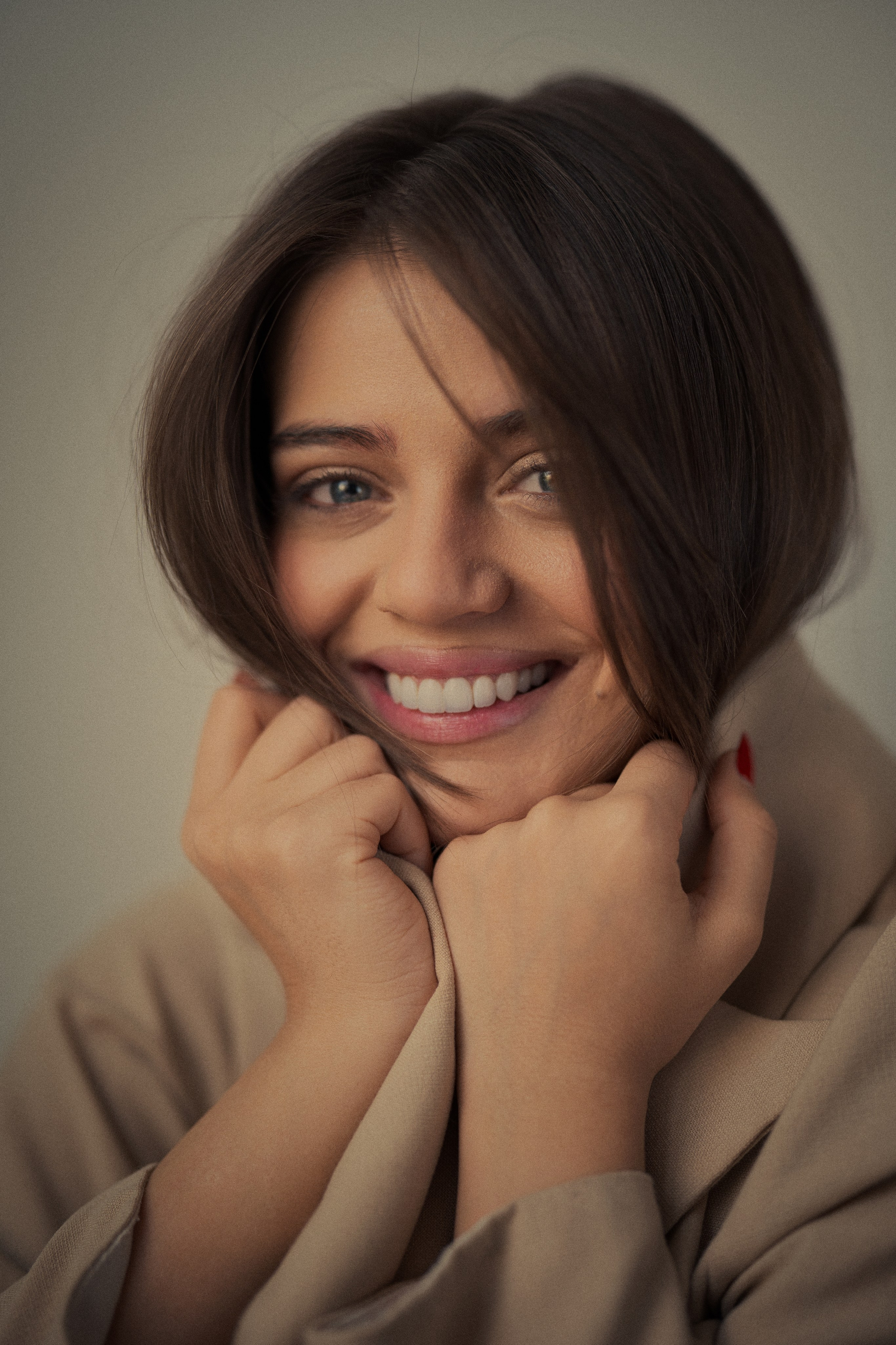 Close-up female portrait photography by Mehran Hadad featuring Forouq Mohamadi smiling naturally with brown hair framing her face and warm neutral styling.