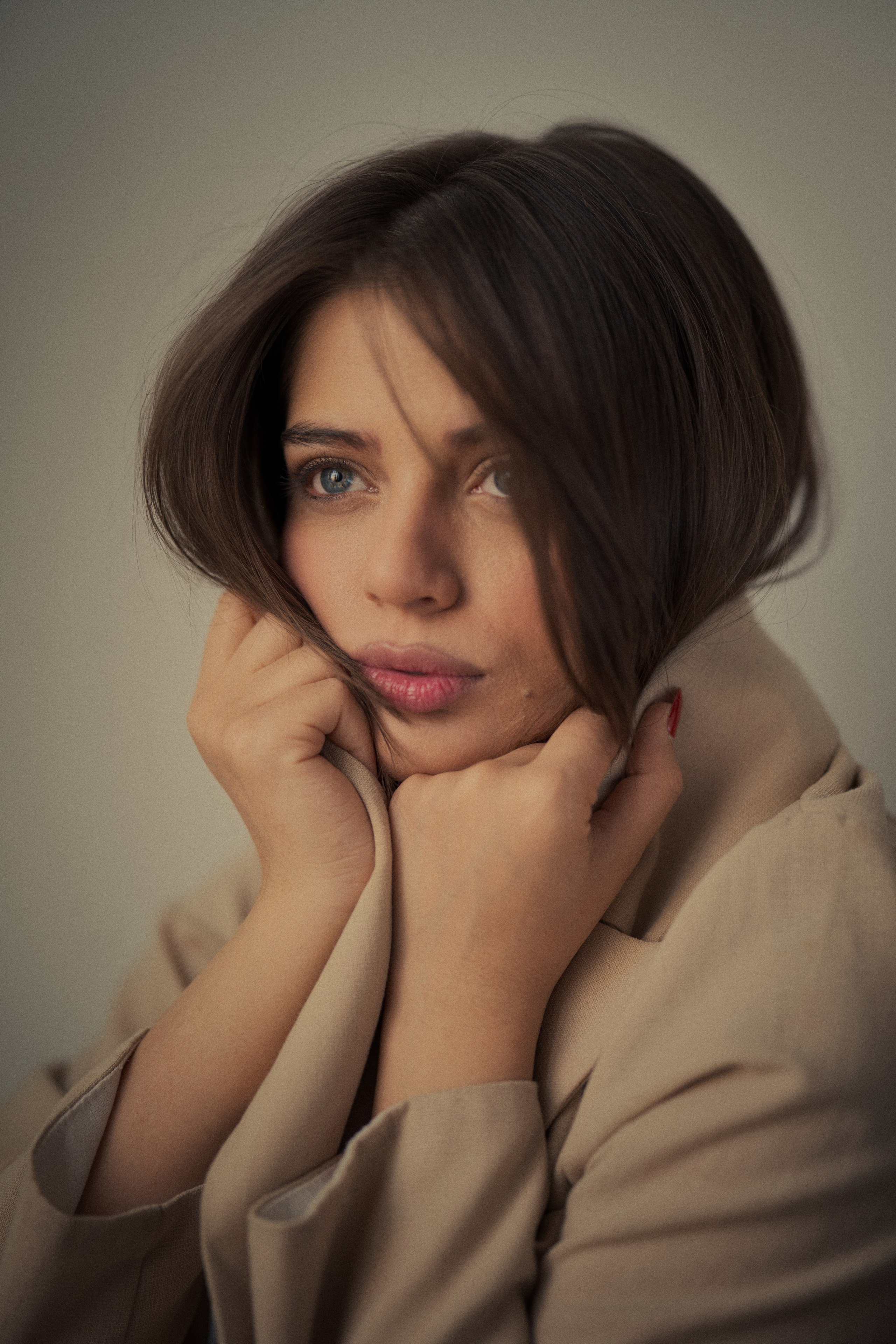 Fine art portrait of Forouq Mohamadi by Mehran Hadad featuring an intimate pose with her face framed by brown hair and a beige blazer.