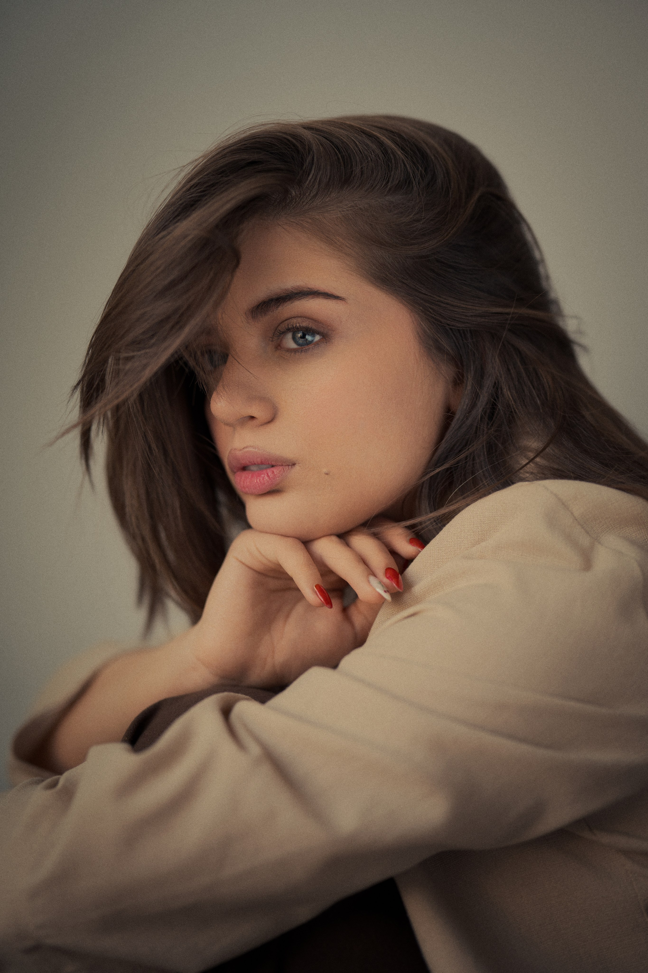 Cinematic side portrait photography by Mehran Hadad featuring Forouq Mohamadi with flowing brown hair, a beige blazer and soft warm natural light.