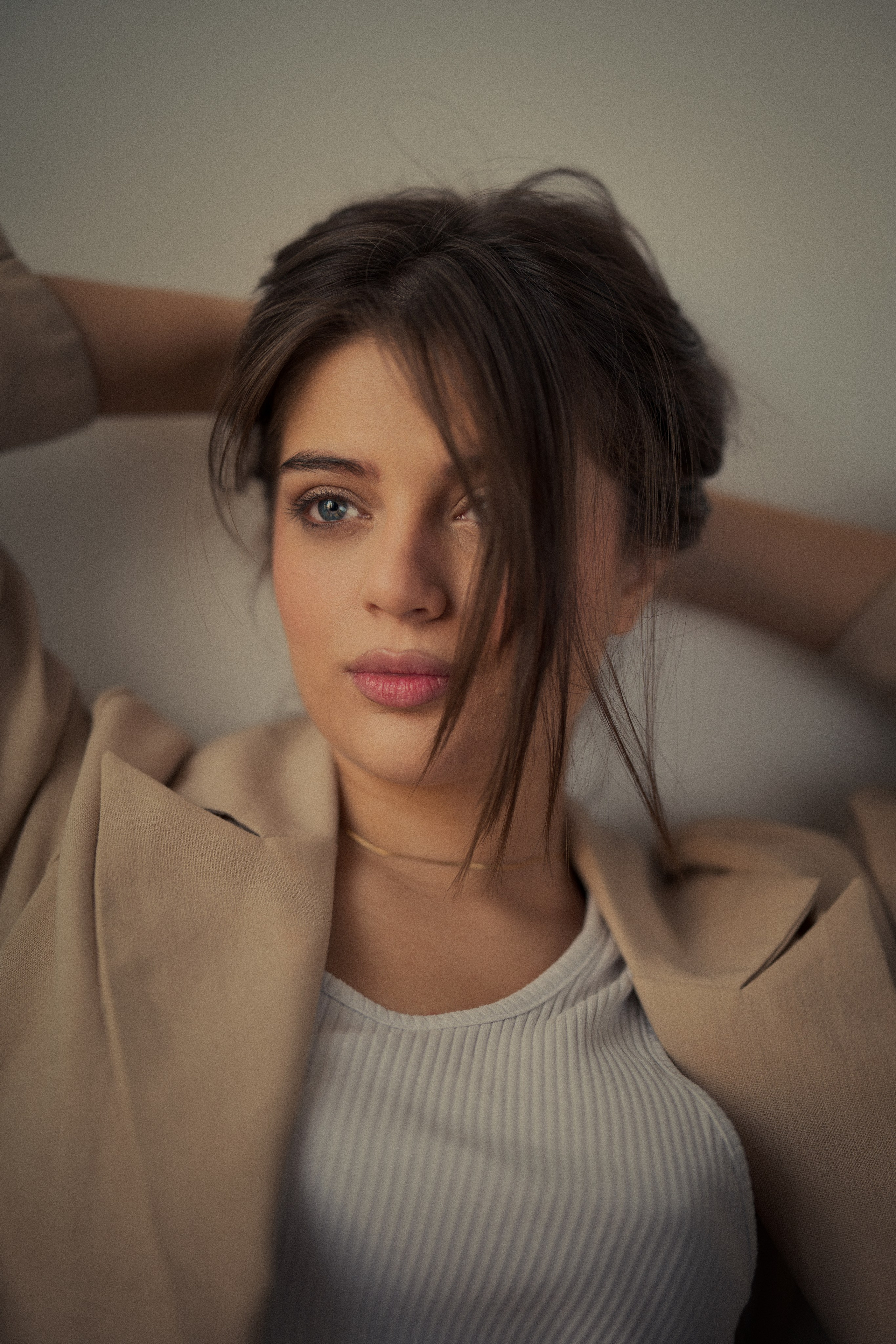 Editorial female portrait photography by Mehran Hadad featuring Forouq Mohamadi with loosely tied brown hair, a beige blazer and soft natural lighting.