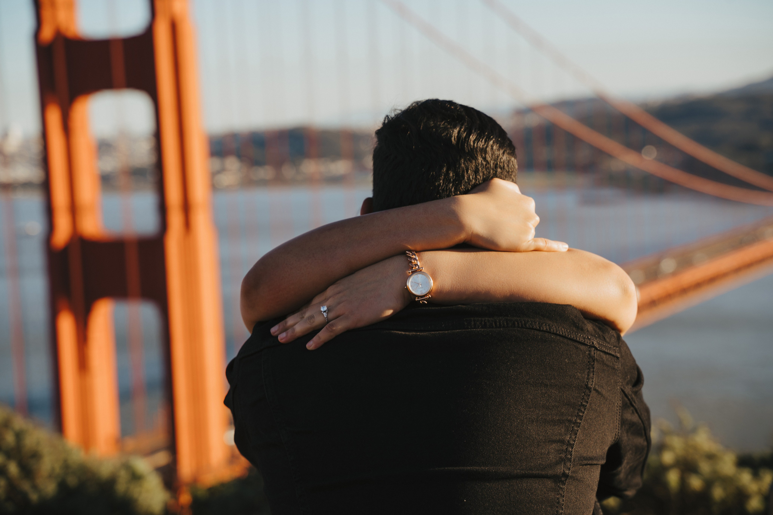 Proposal.  Overlooking the golden San Franisco Bridge sunset with a couple. Photographer Video. 