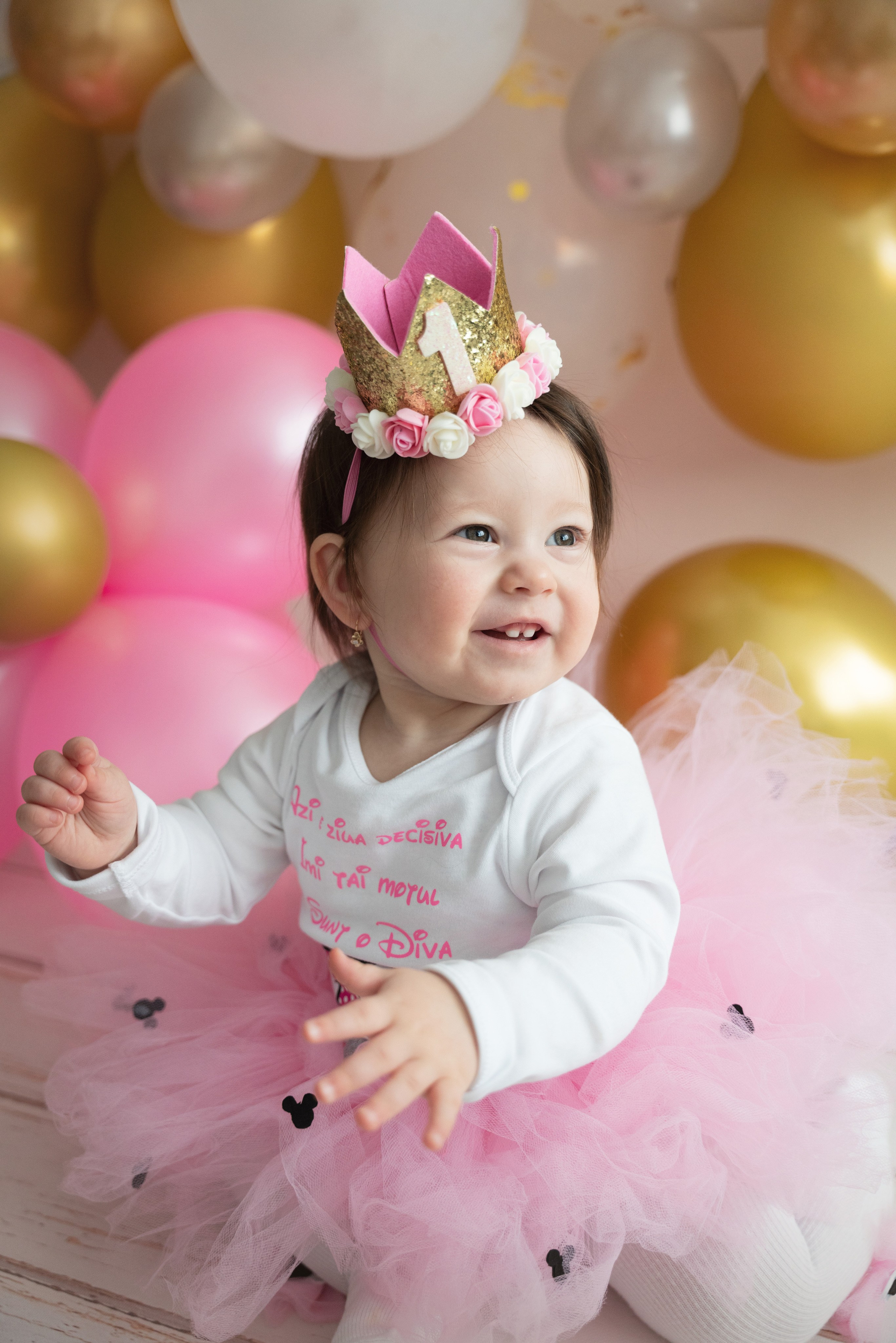 festliches Fotoshooting eines einjährigen Mädchens mit Krone und Luftballons