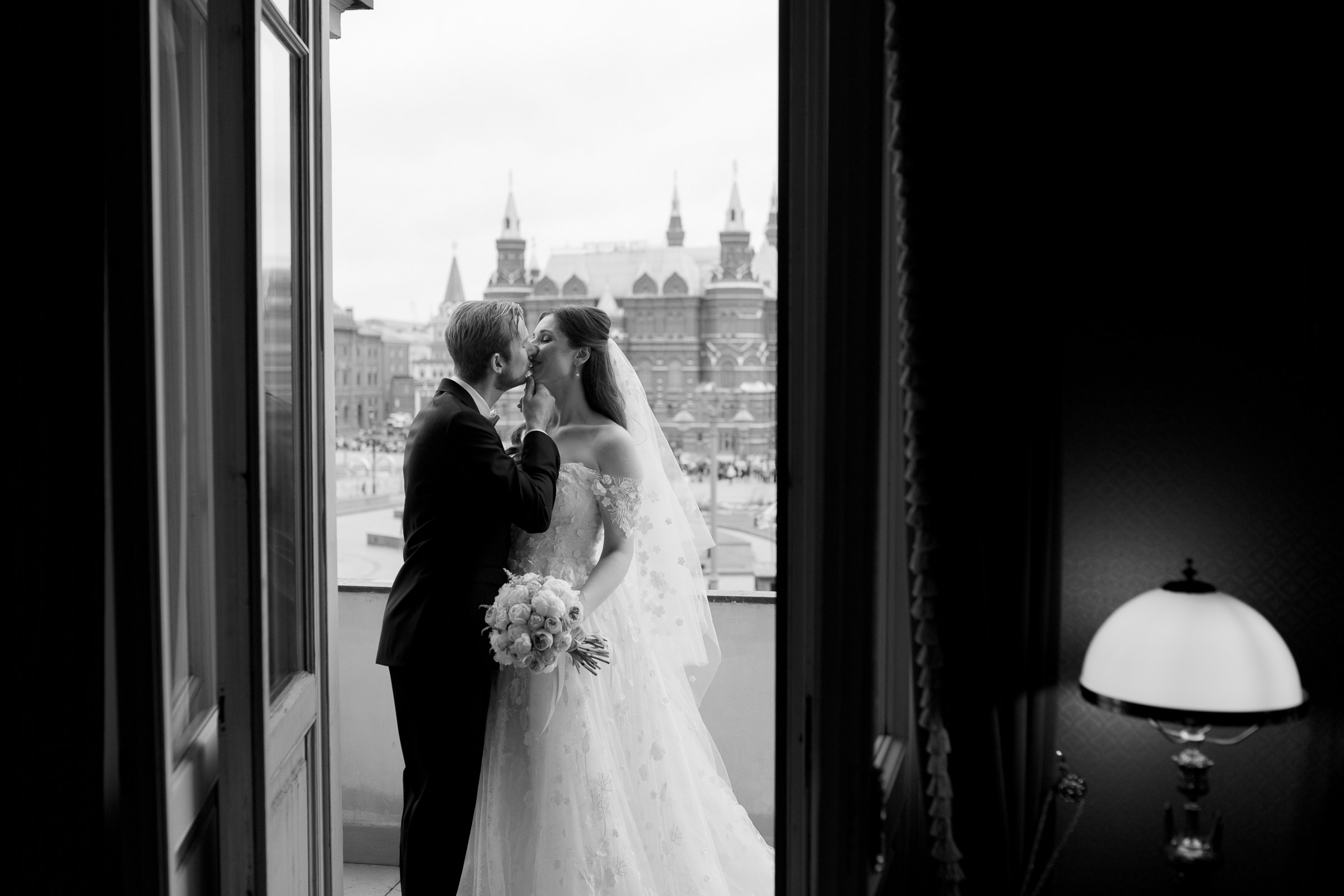 Couple’s morning kiss on balcony, by Bude, wedding photographer.