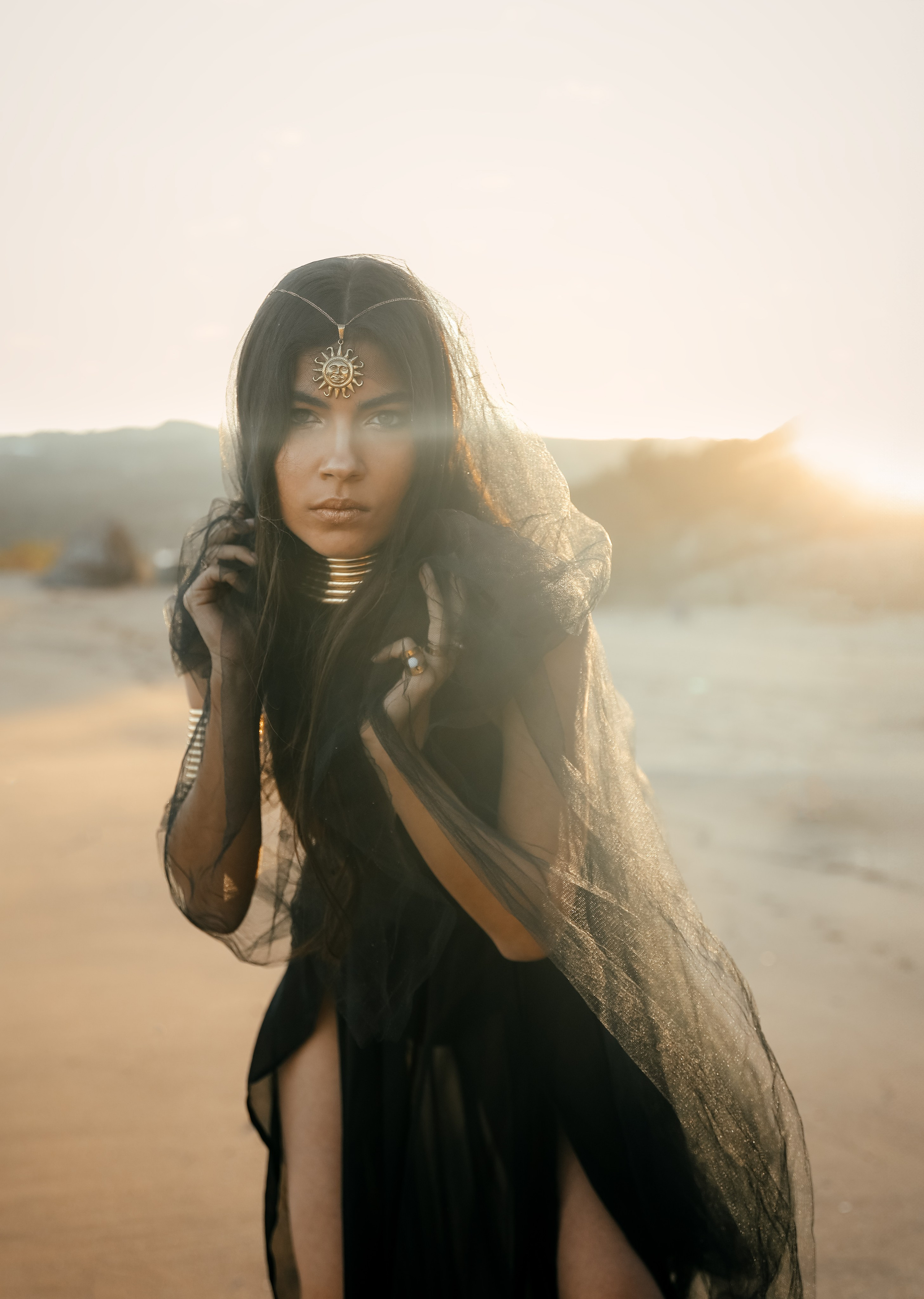 A chic girl in a black dress in the Desert against the setting sun. Rhodes island, Greece
