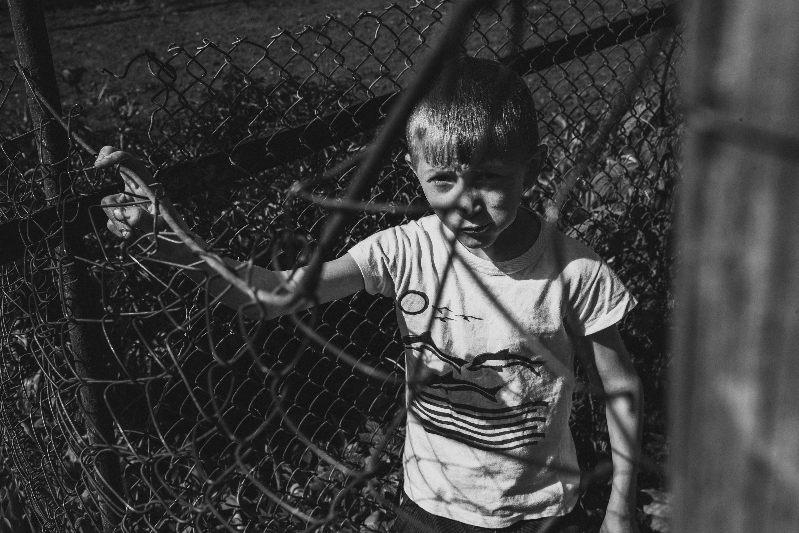 чёрно-белая социальная документальная фотография портрет бедность мальчик сетка любопытство Фотограф в Ирландии