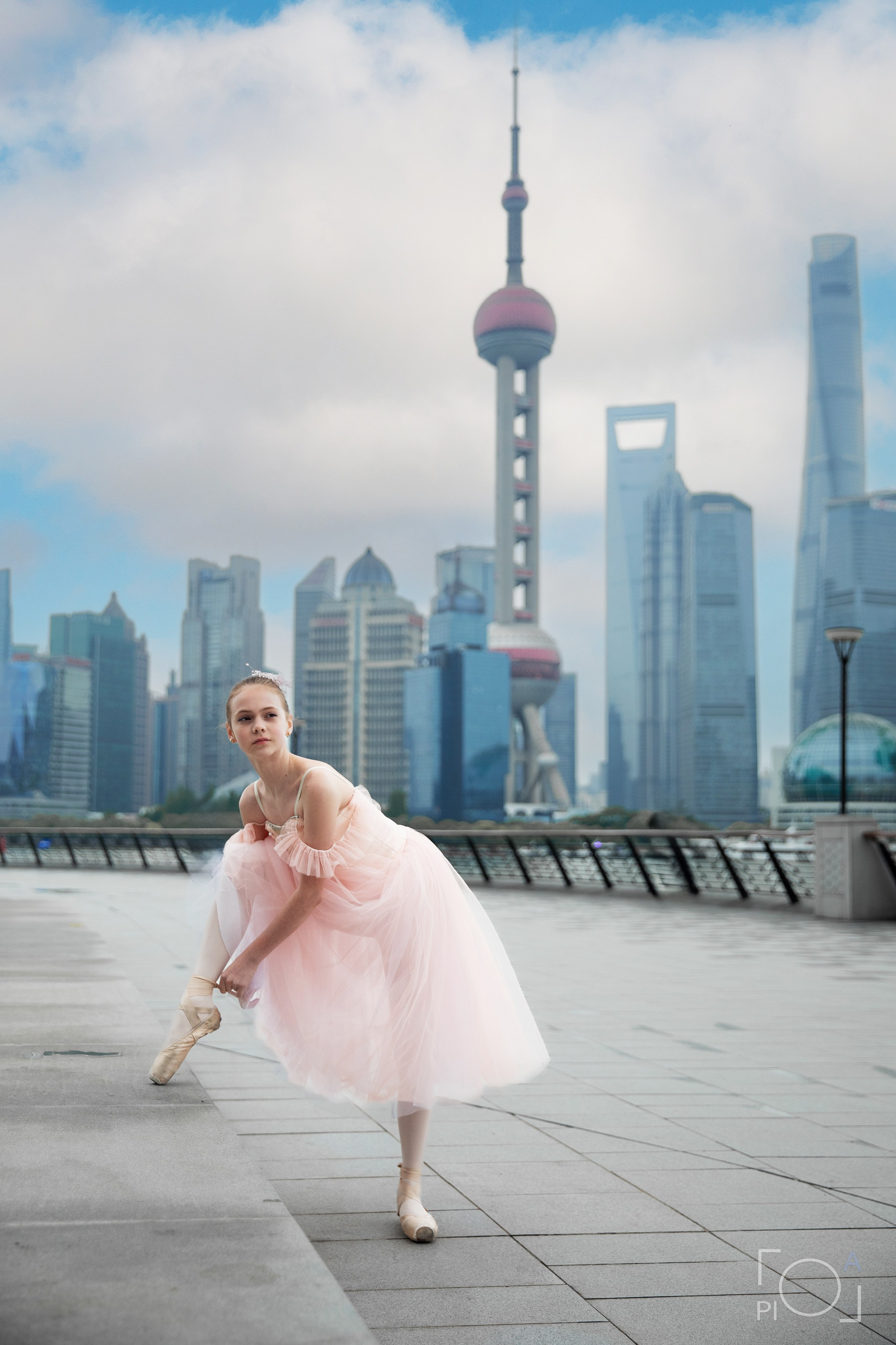 Фотосессия в Шанхае для девочки 11 лет. Маленькая балерина в розовом платье с пышной длинной пачкой, танцует на набережной в Шанхае с видом на Lujiazui
