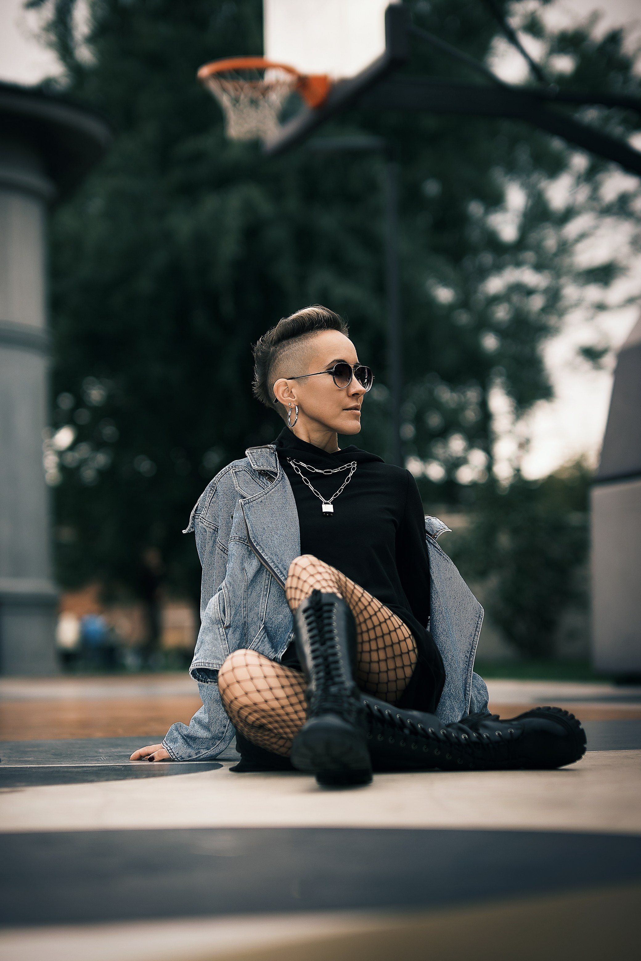 Уличная фотосесия красивая девушка на кресле в поле в черном плаще