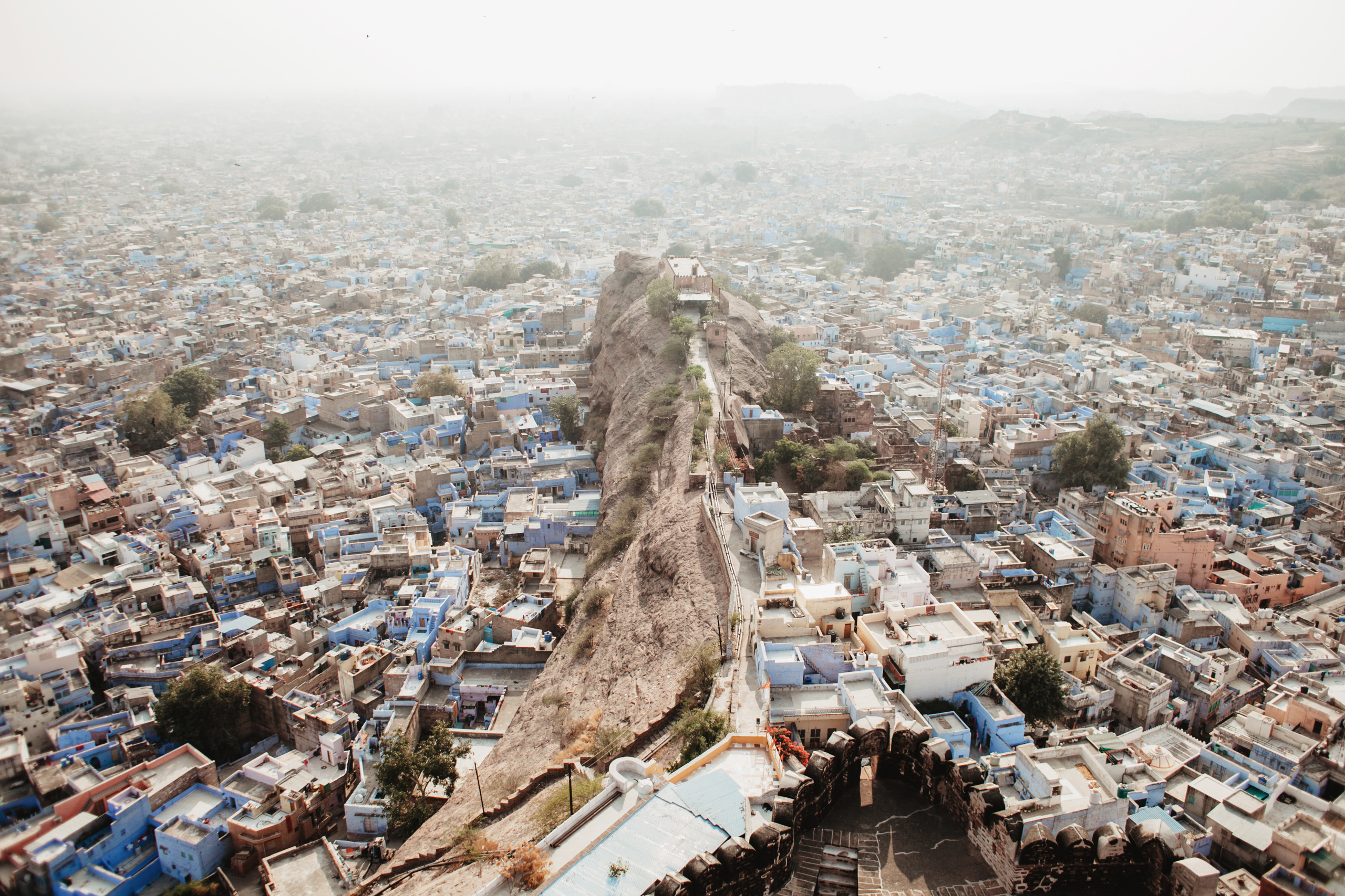 Читая и слушая описания города, возможно, вы по ошибке представите улицы марокканского Шефшауэна. Насыщенное синее пламя. Однако в Джодхпуре синева не абсолютна и скорее похожа на мираж. Синий постоянно ускользает от вас. Глубина улиц отчетливо тонет под шалью синевы, но она как будто принадлежит сама себе. На фото ее тяжело словить, а подходя ближе к конкретным домам и переулкам вы теряете ее в пыли, мириадах чужеродных деталей, ветхом крошащемся кирпиче.