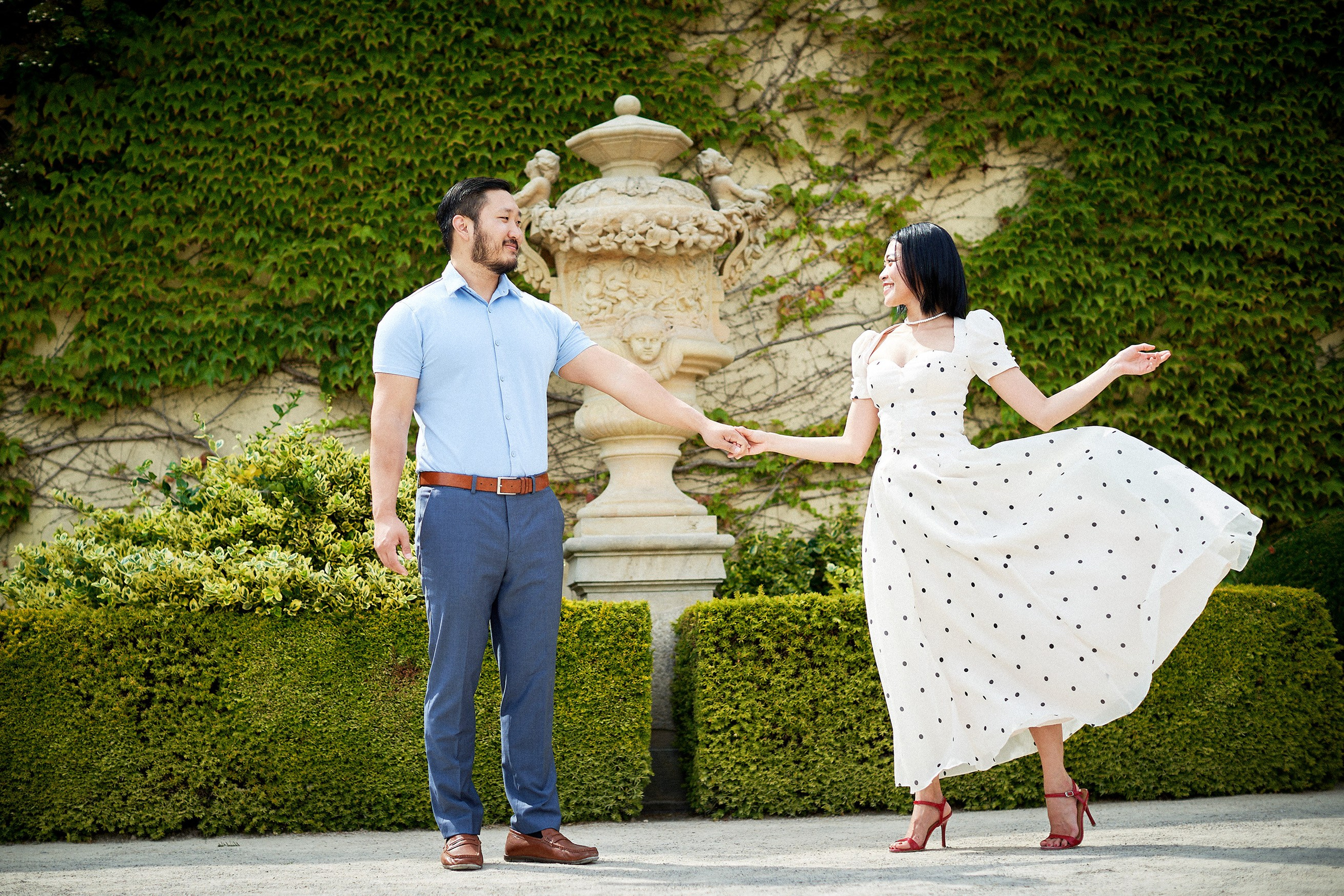 Woman playfully flipping her dress during a lighthearted moment in Vrtba Garden.