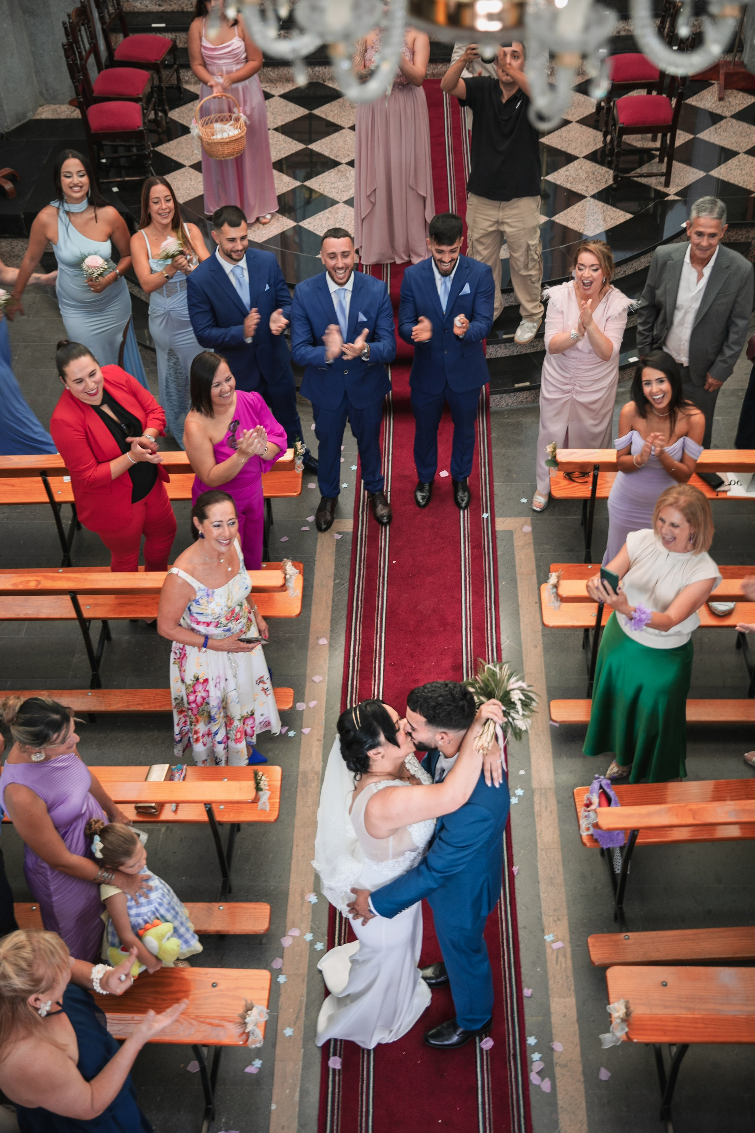 Beso de los novios en el pasillo de la iglesia visto desde arriba