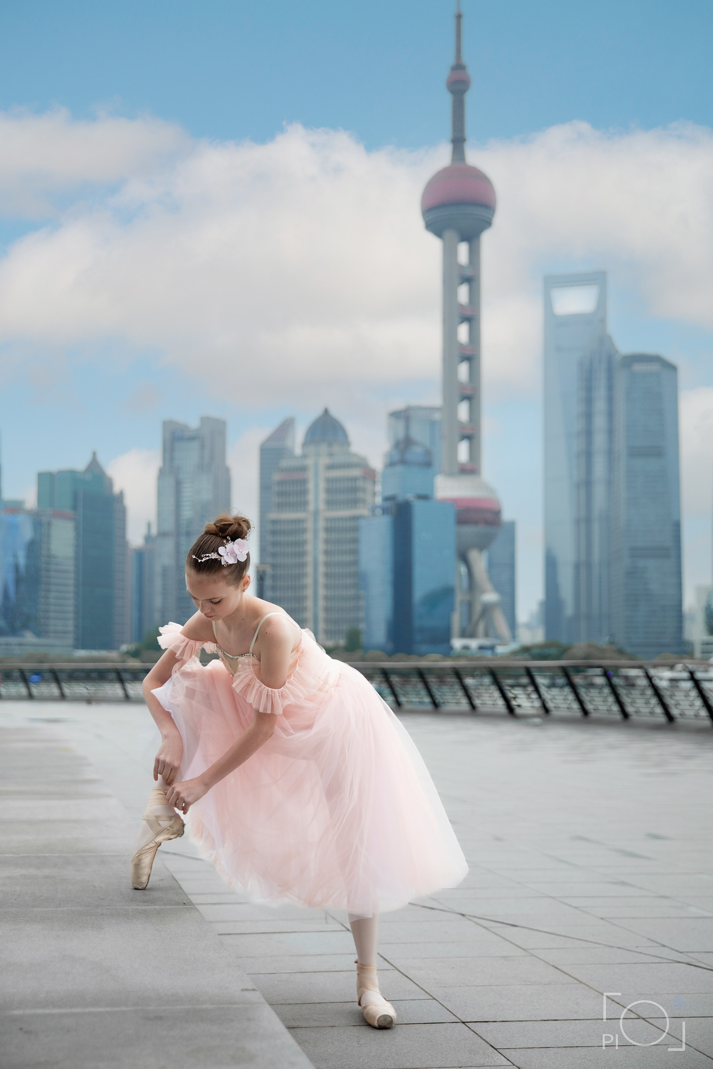 Фотосессия в Шанхае для девочки 11 лет. Маленькая балерина в розовом платье с пышной длинной пачкой, танцует на набережной в Шанхае с видом на Lujiazui