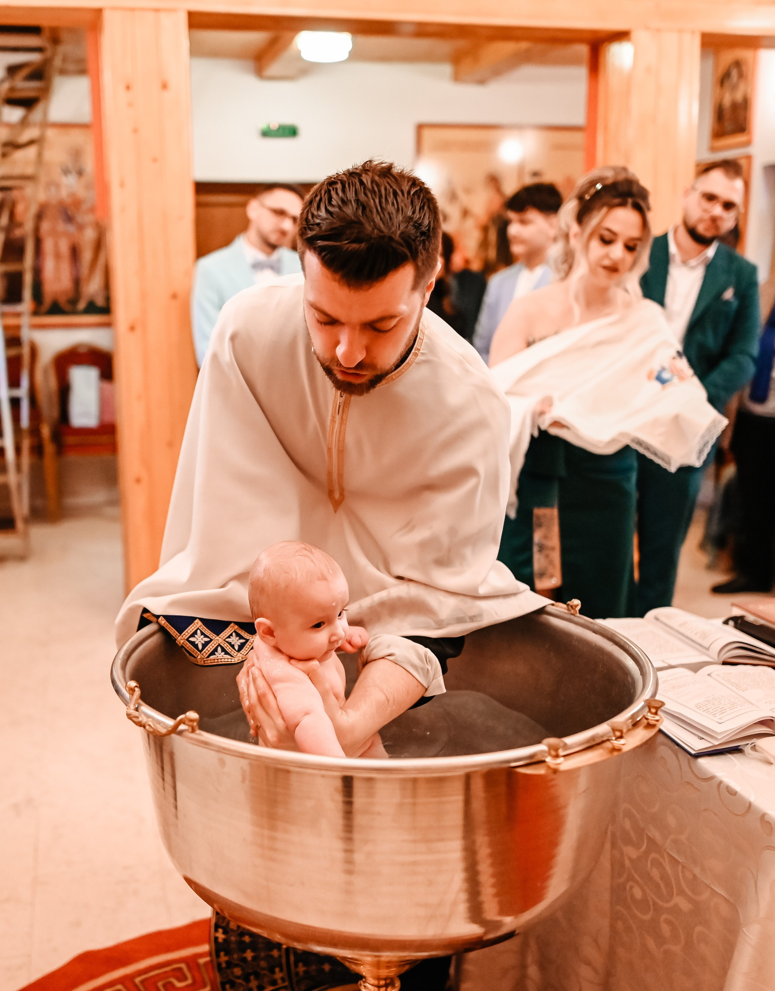 Momentul scoaterii copilului din cristelniță – expresii autentice surprinse de Ana Maria Drăgan