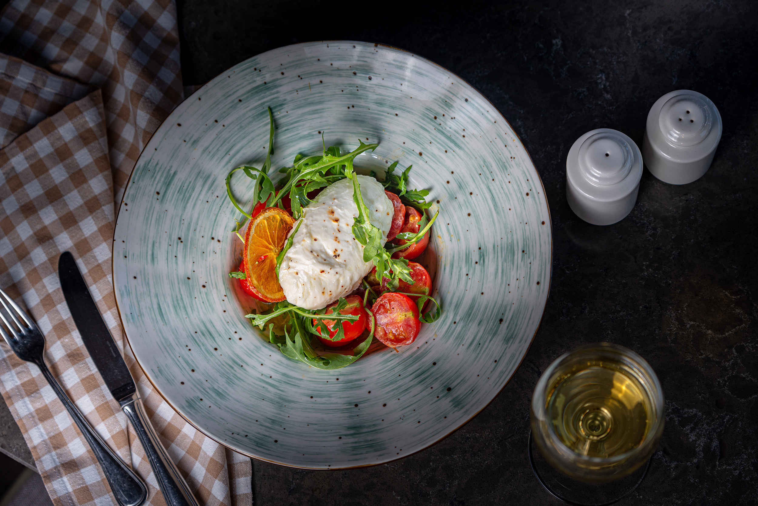 Fresh burrata cheese and citrus salad served in a deep plate