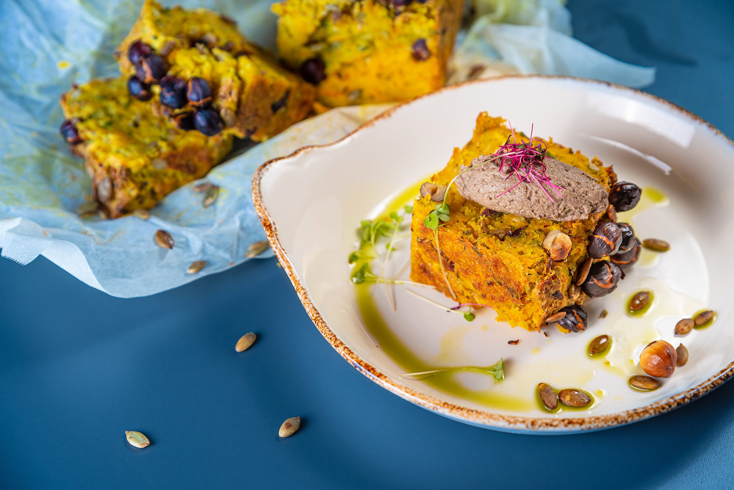 Vegetable bread with nuts and sauce, served on a turquoise table
