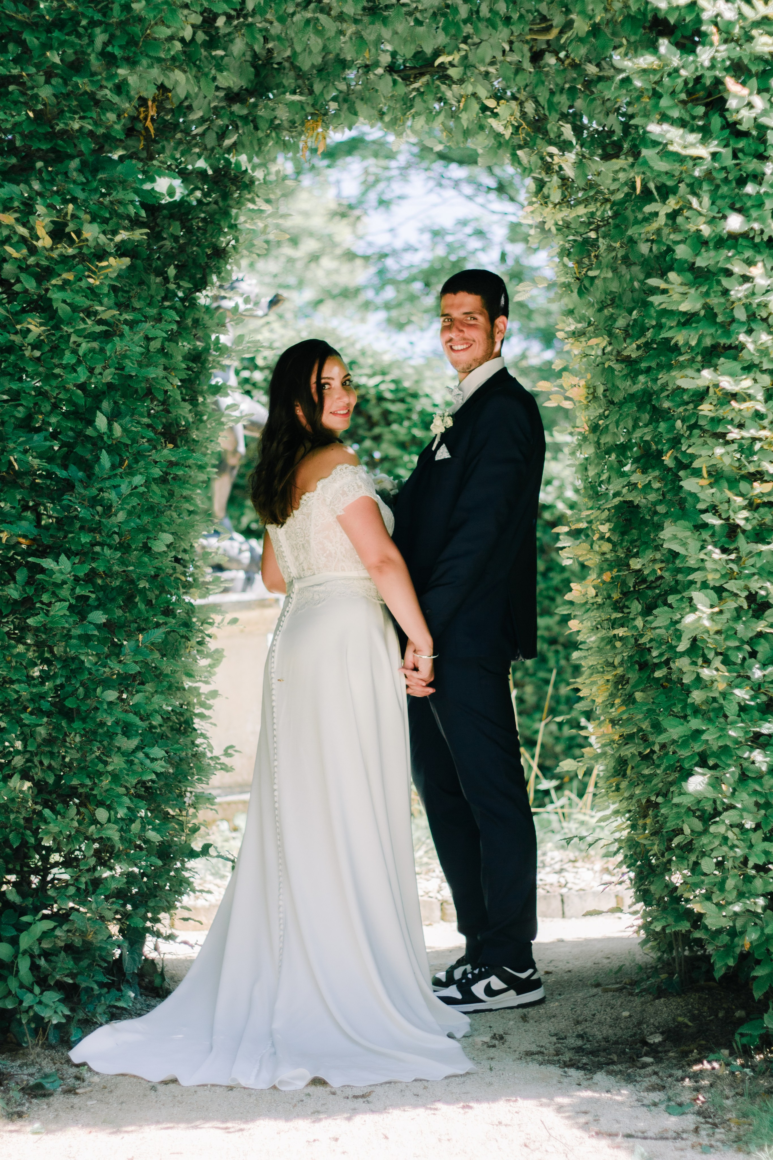 Couple de mariés marchant main dans la main au Parc de Blossac à Poitiers