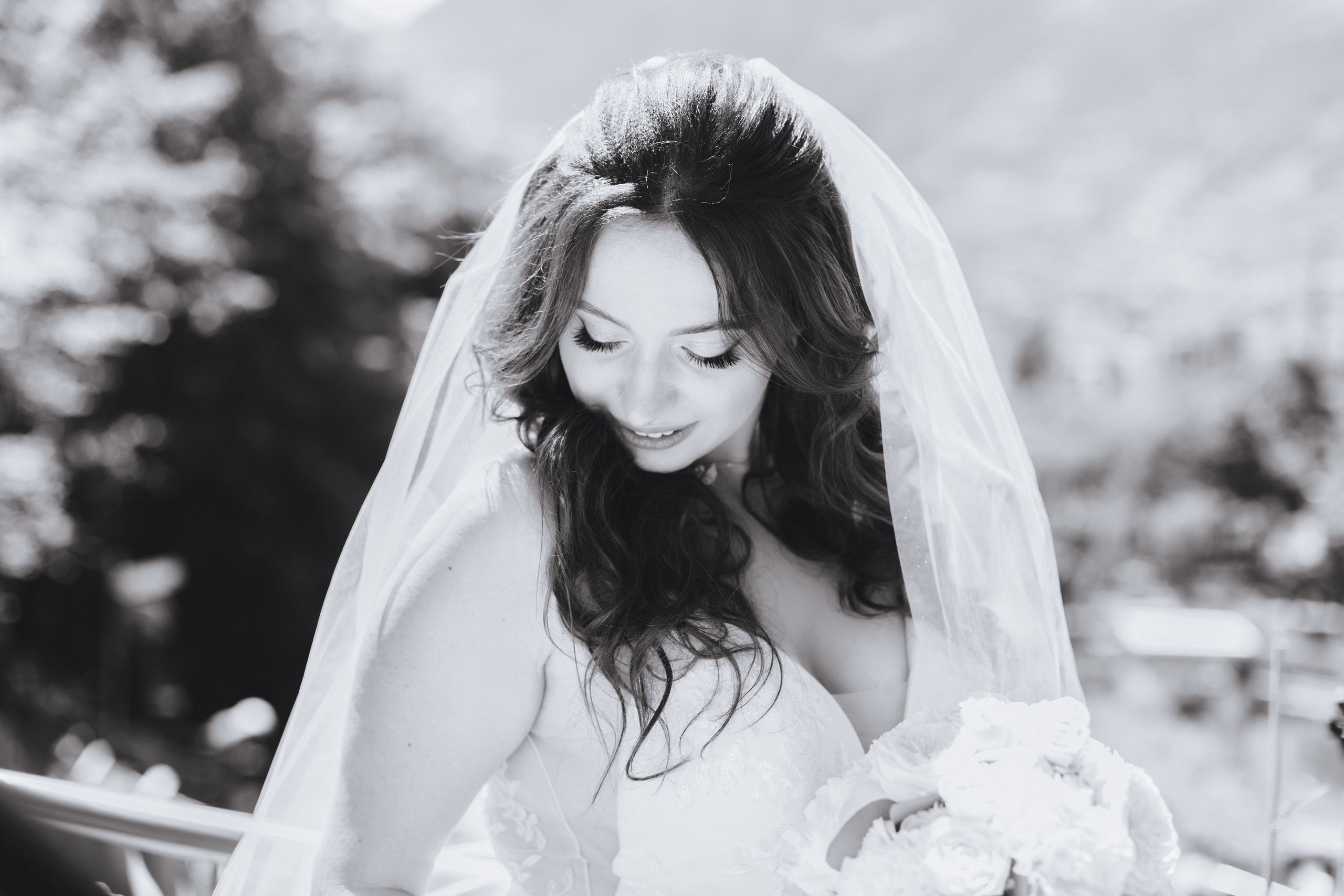 Die Braut schaut nach unten, ein ruhiger Moment der Reflektion und Eleganz an ihrem großen Tag.