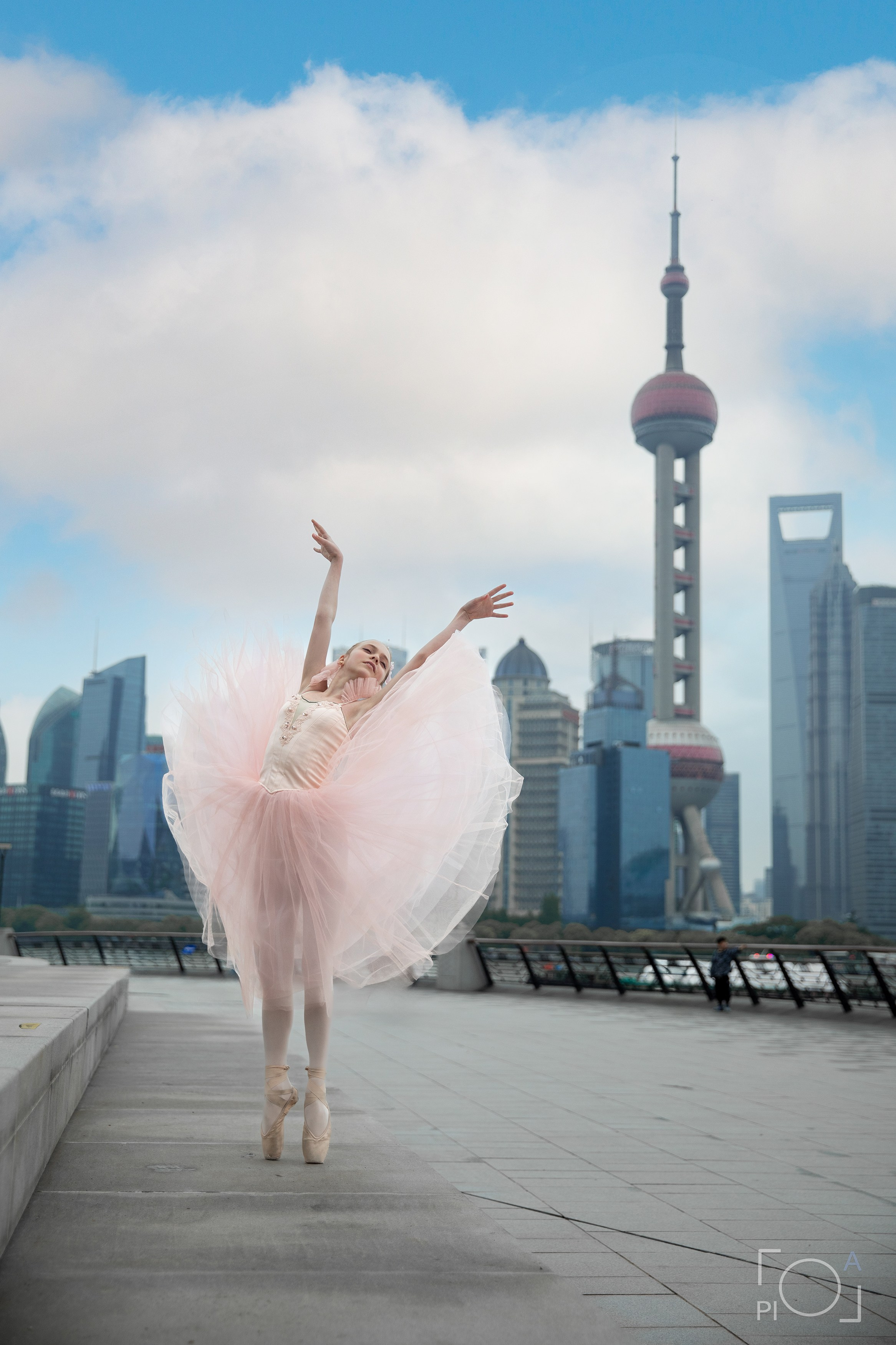 Фотосессия в Шанхае для девочки 11 лет. Маленькая балерина в розовом платье с пышной длинной пачкой, танцует на набережной в Шанхае с видом на Lujiazui