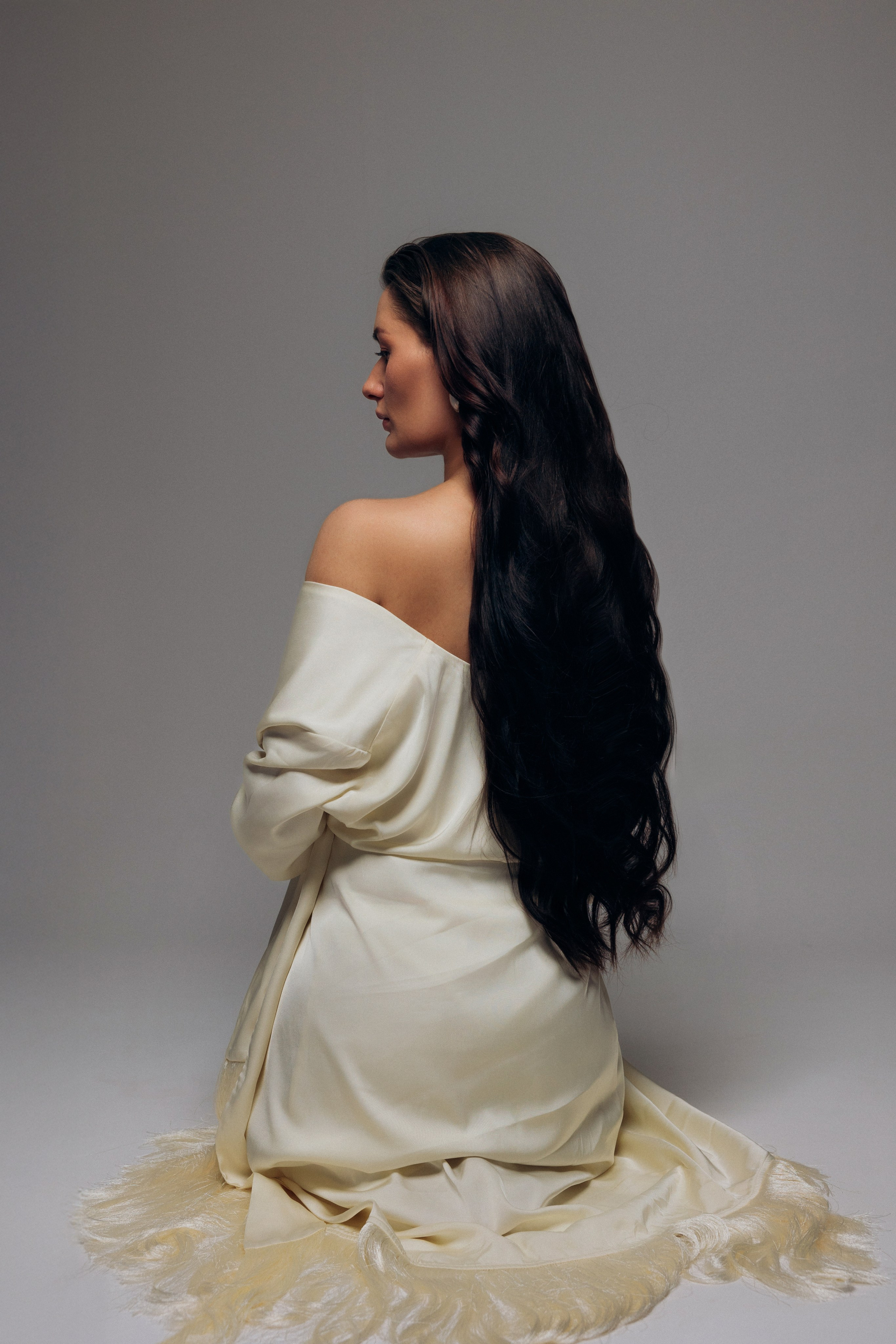 Minimalistyczna sesja ciążowa Szczecin – kobieta w profilu, dłonie na brzuchu, światło i cień. Minimalist maternity session Szczecin – woman in profile, hands on belly, light and shadow play.