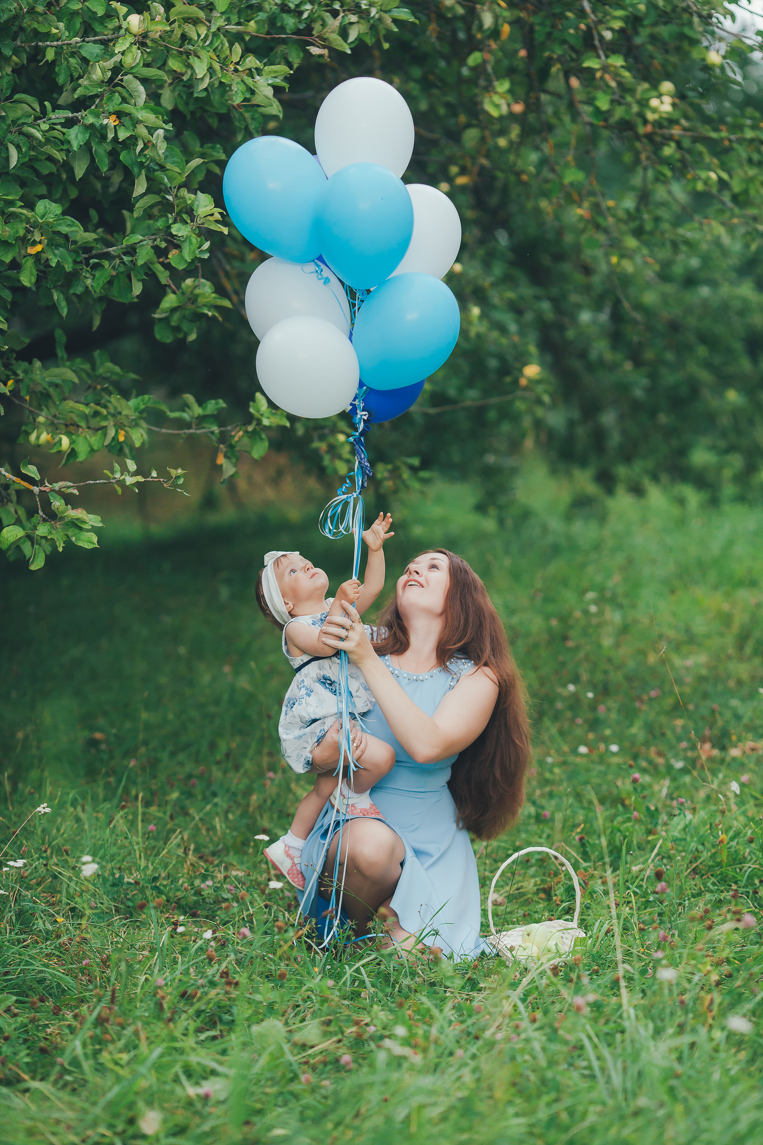 Мама с дочкой радуются воздушным шарикам.