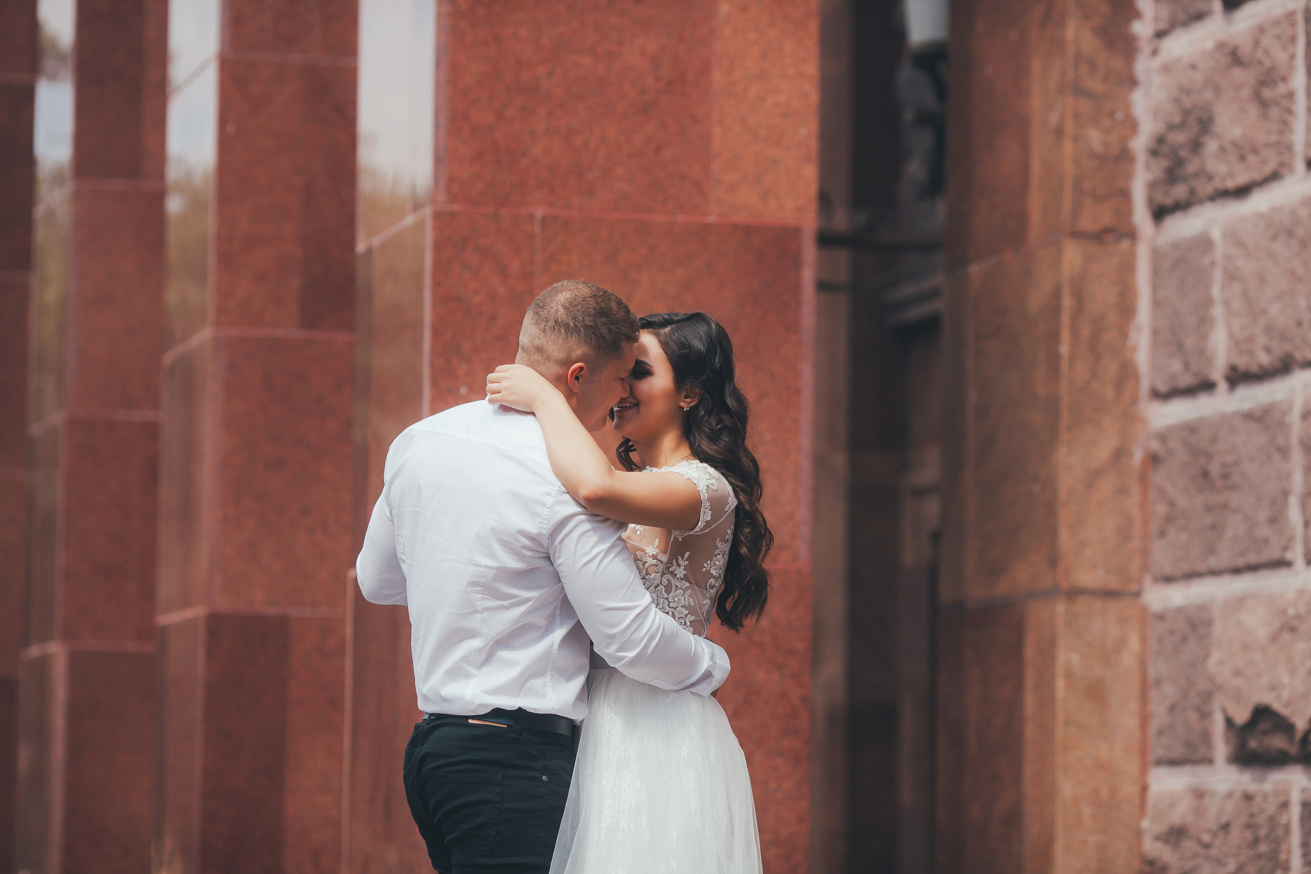 Свадебная пара обнимается у драмтеатра в парке Смоленска.