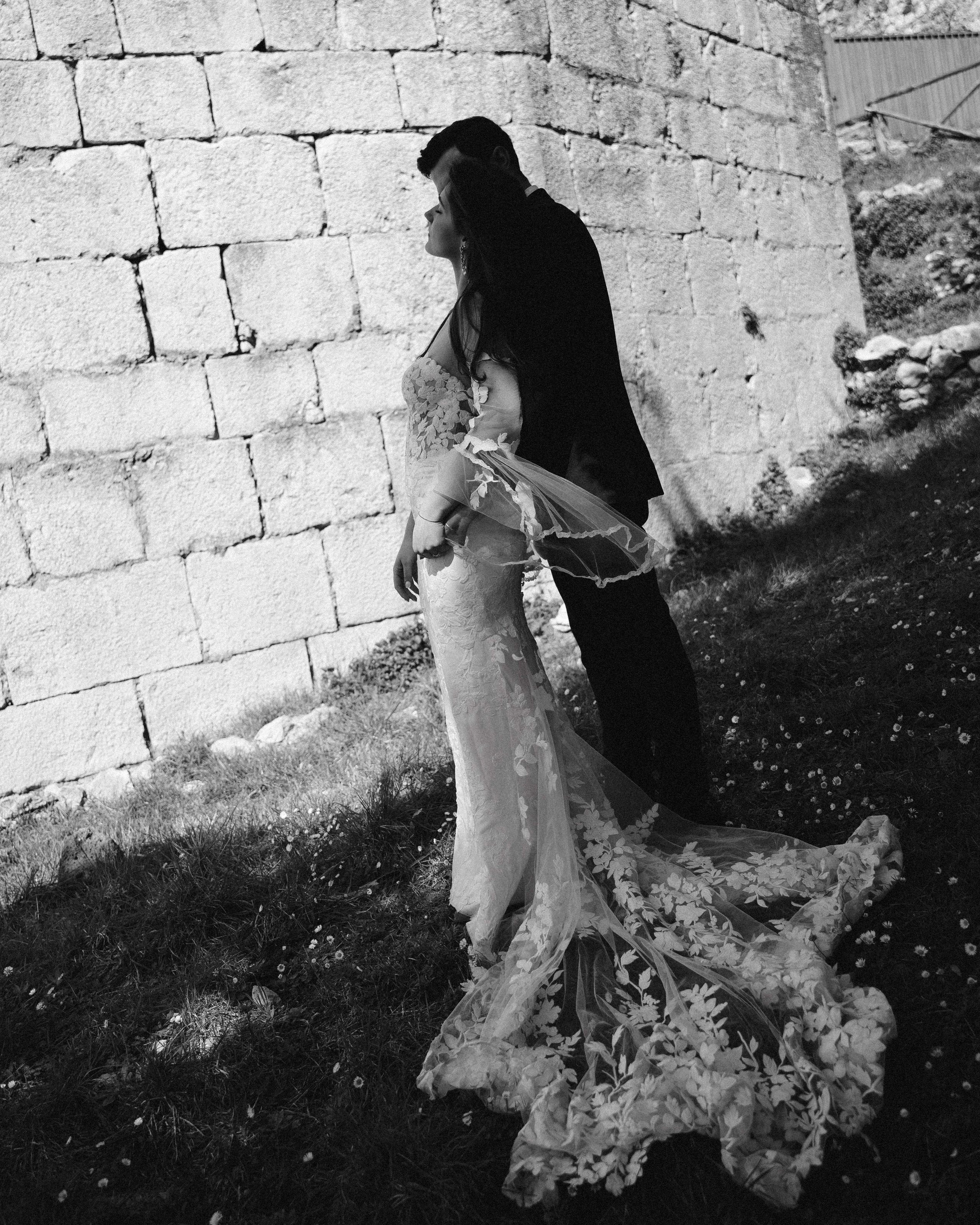 Black and white romantic portrait of the bride leaning on the groom
