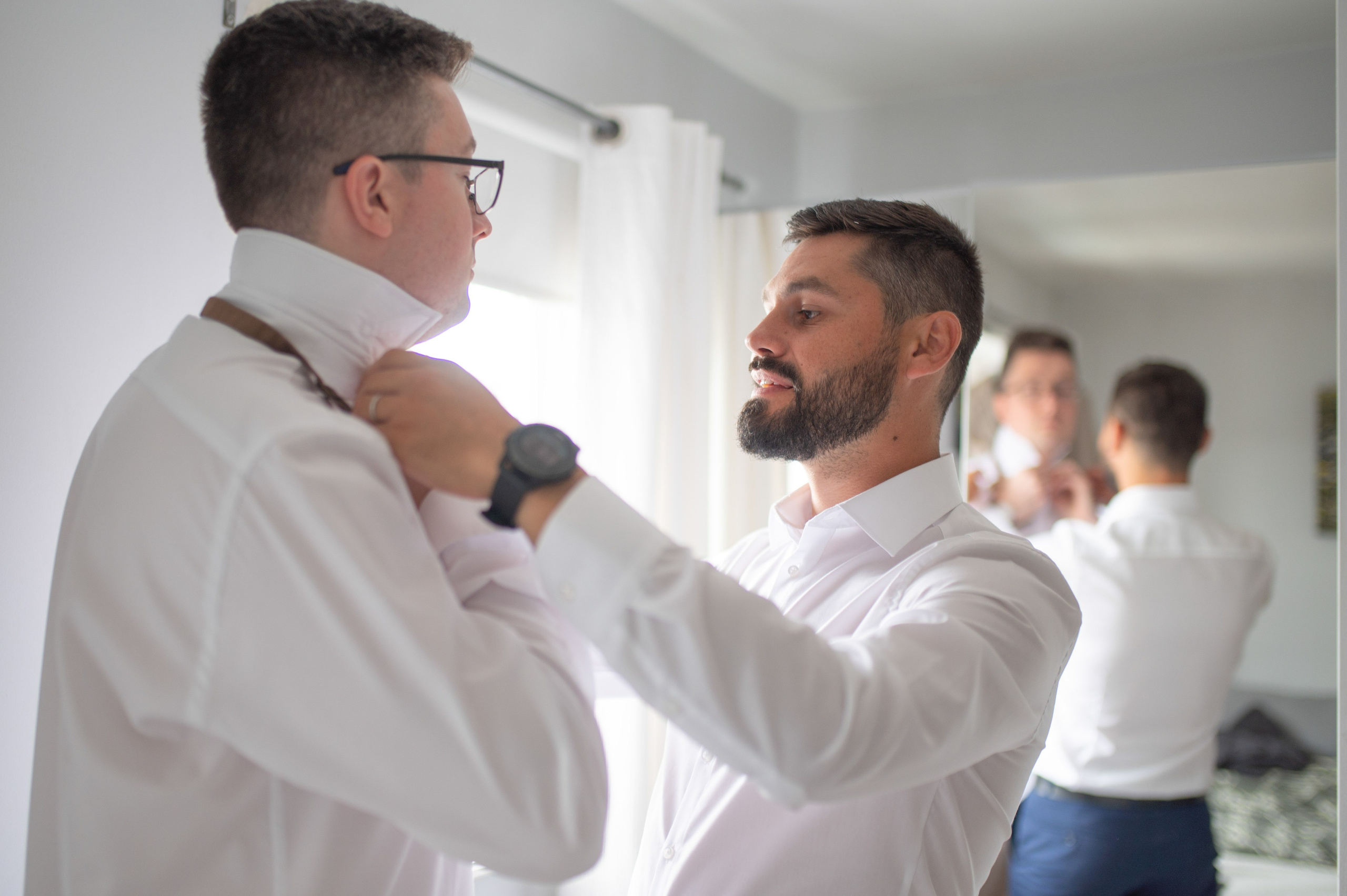 Groomsman adjusting the groom's collar and tie before the ceremony, Charlecote Pheasant Hotel