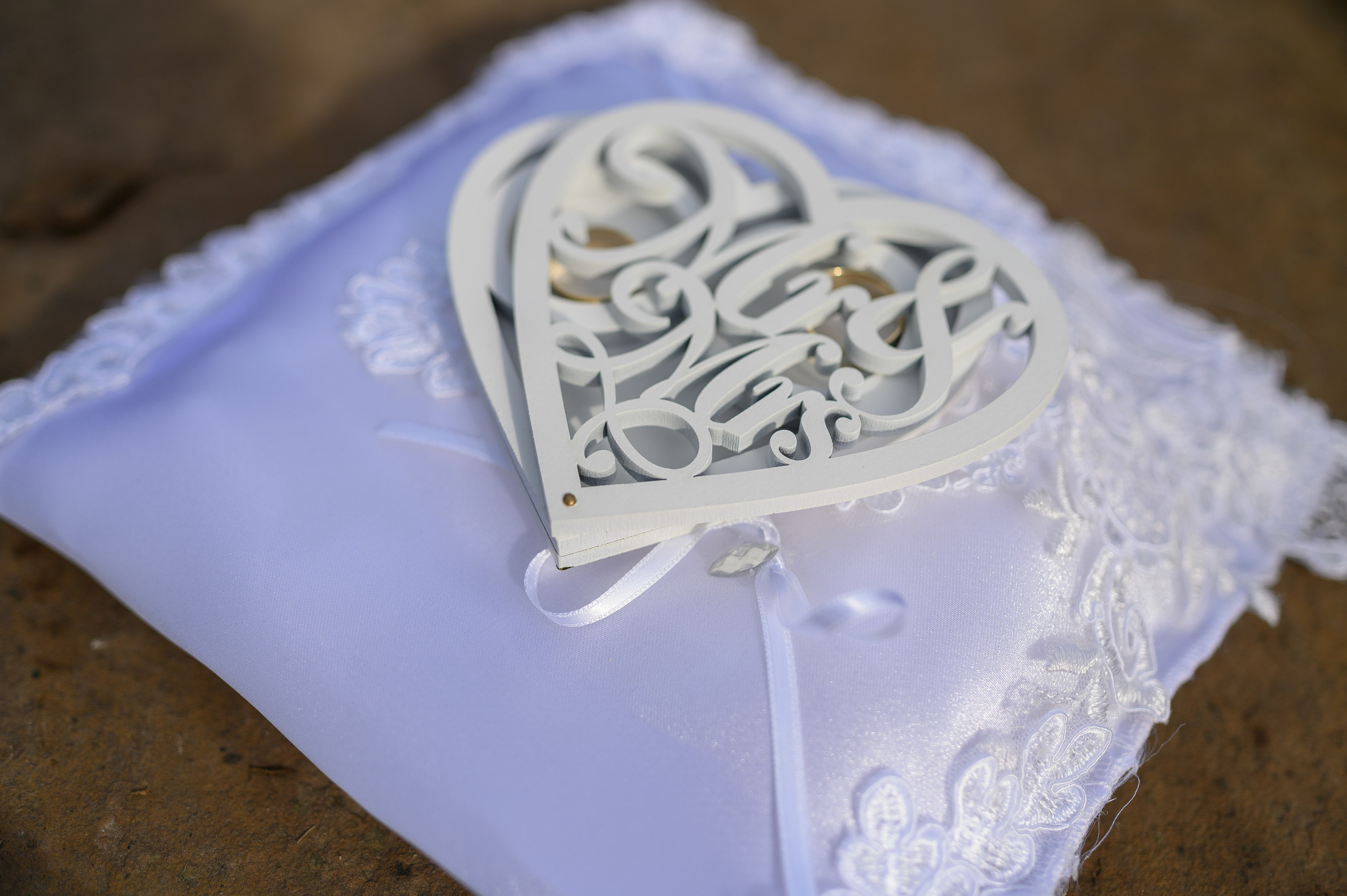 Close-up of a lace-trimmed heart-shaped wedding ring pillow