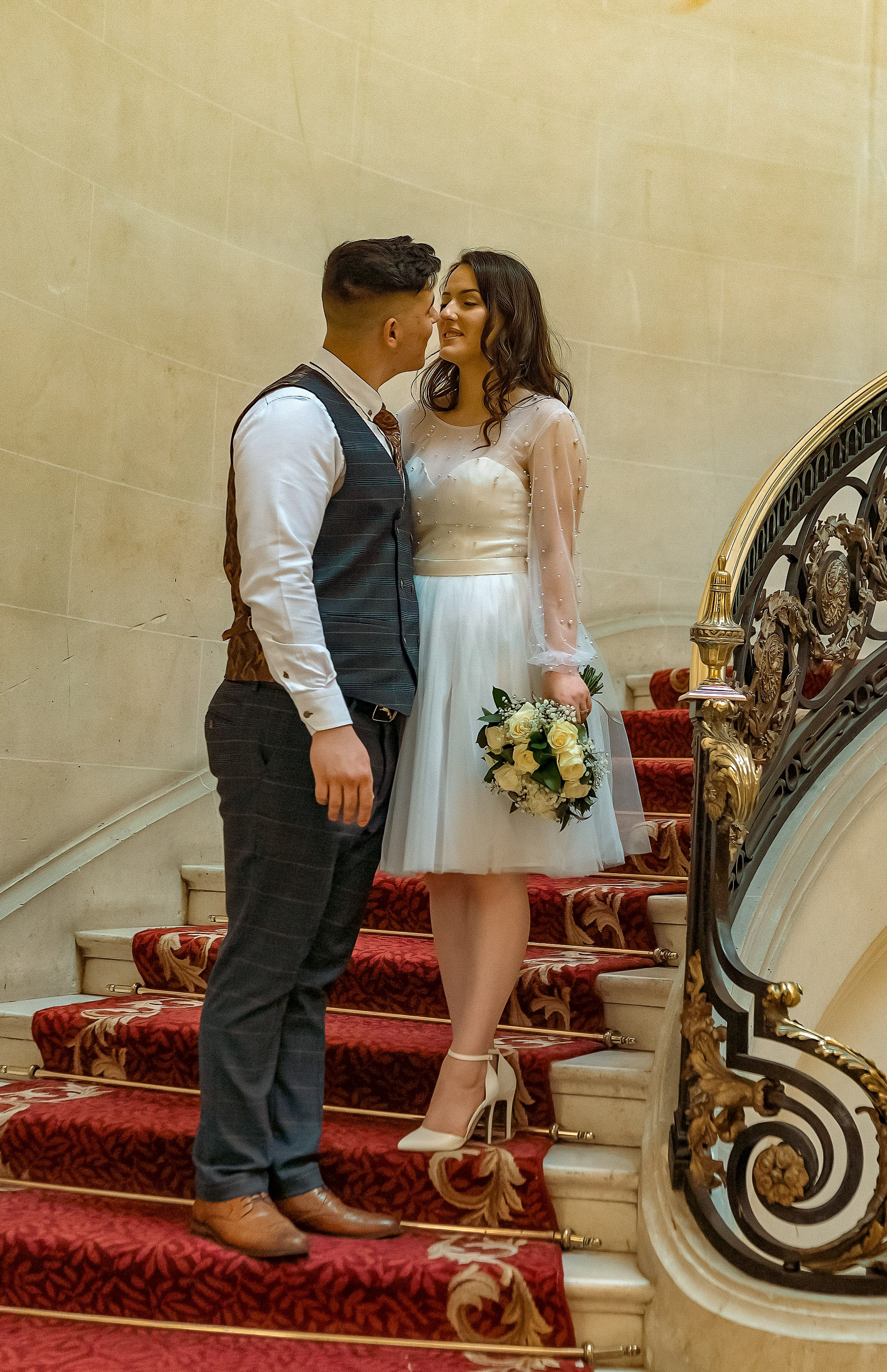 Bride and groom standing together on the grand staircase at Luton Hoo, Bedfordshire