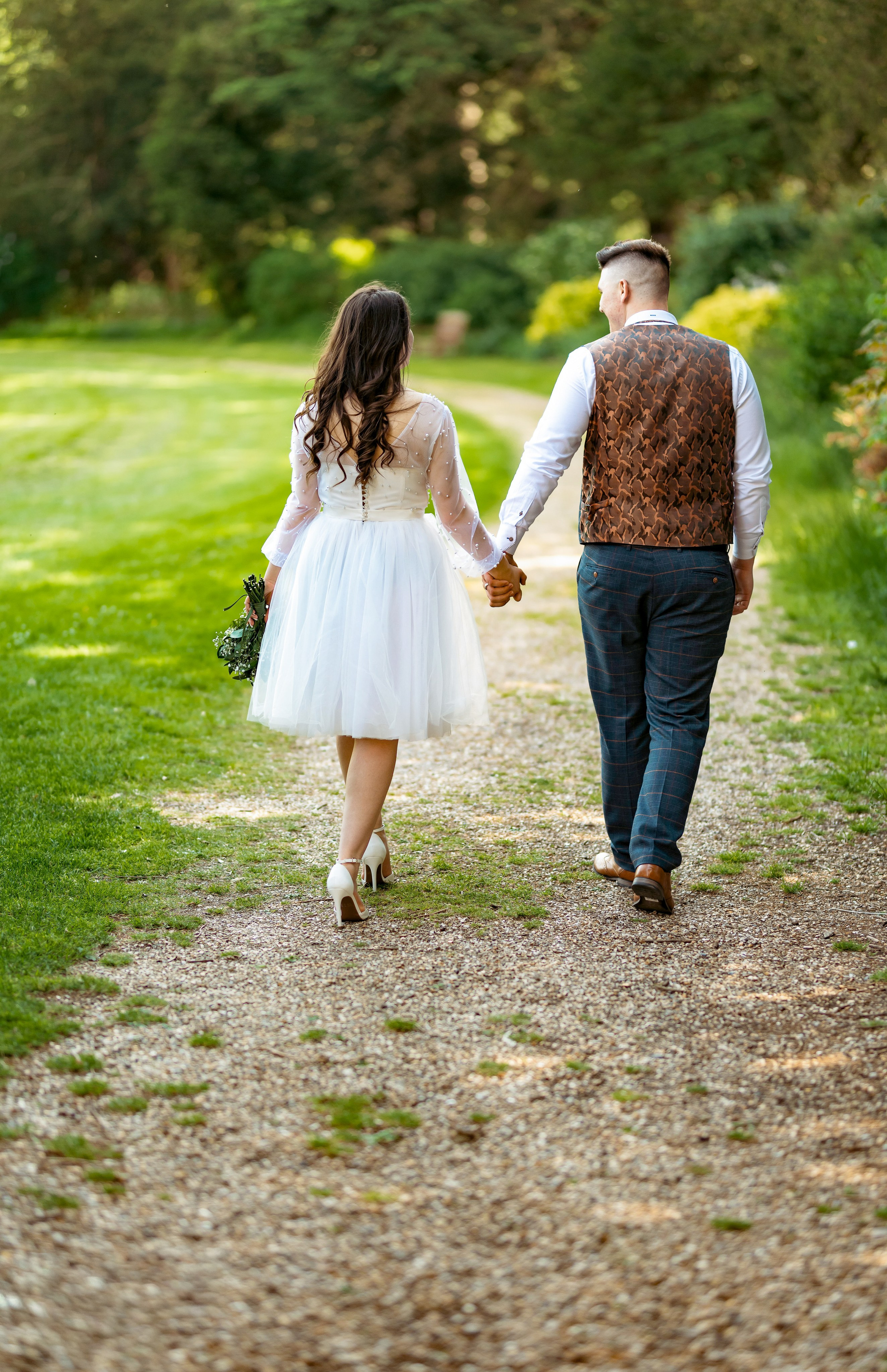 Bride and groom walking near a garden folly at Luton Hoo