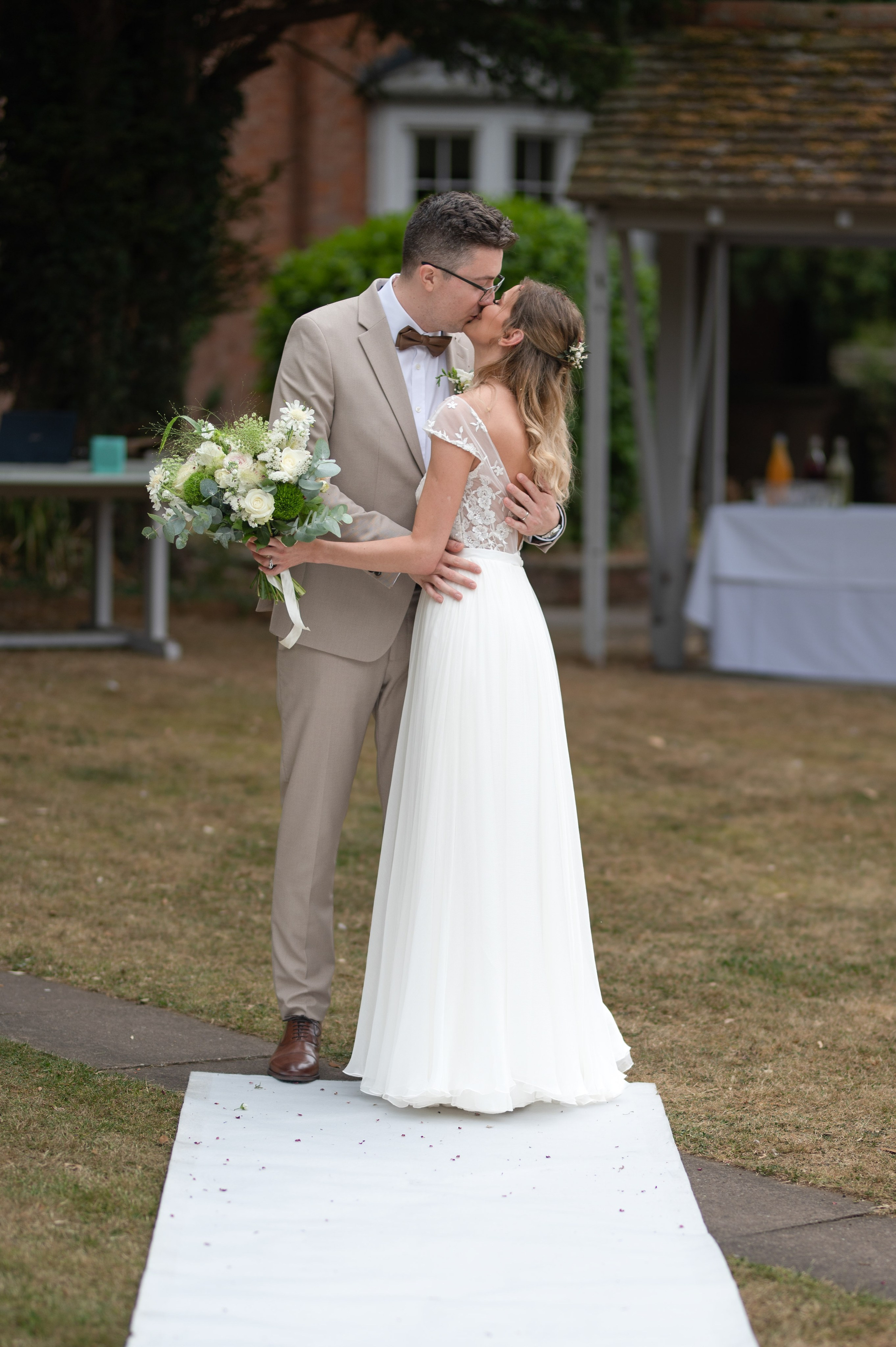 Bride and groom sharing their first kiss as newlyweds at Charlecote Pheasant Hotel