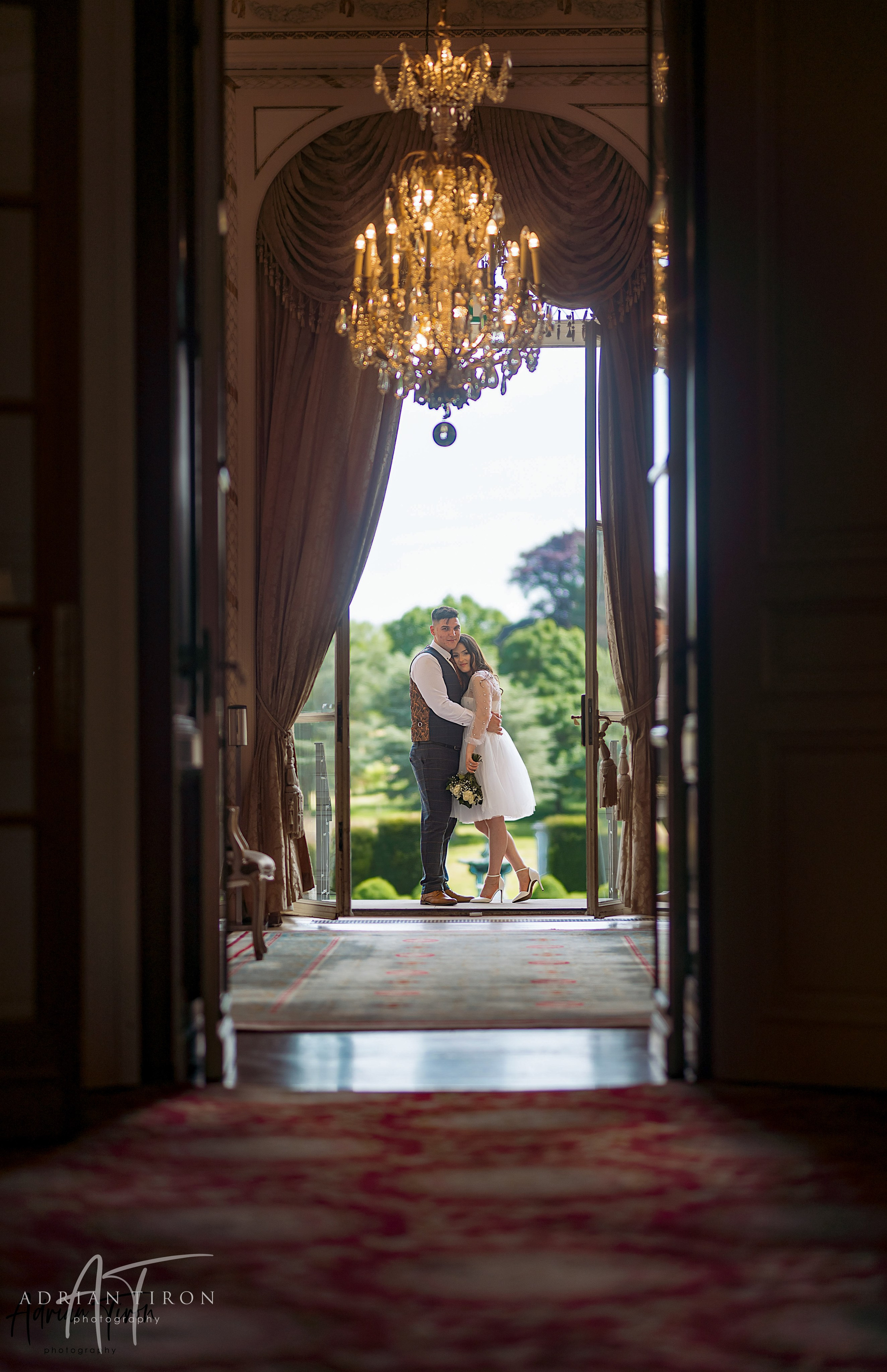 Bride and groom sharing an intimate moment in a mansion hallway at Luton Hoo