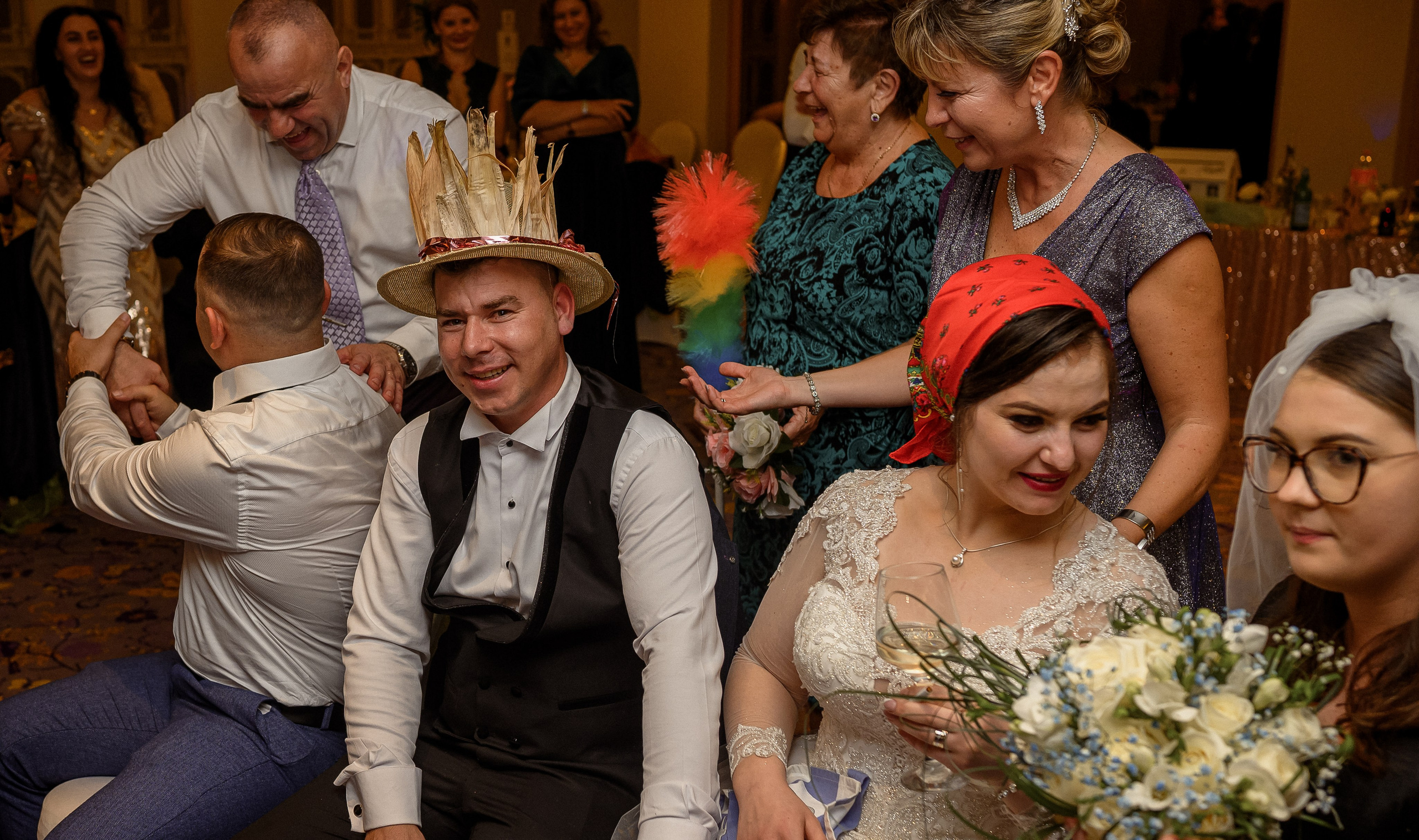 Guests celebrating with the bride at the reception, one wearing a gold party crown