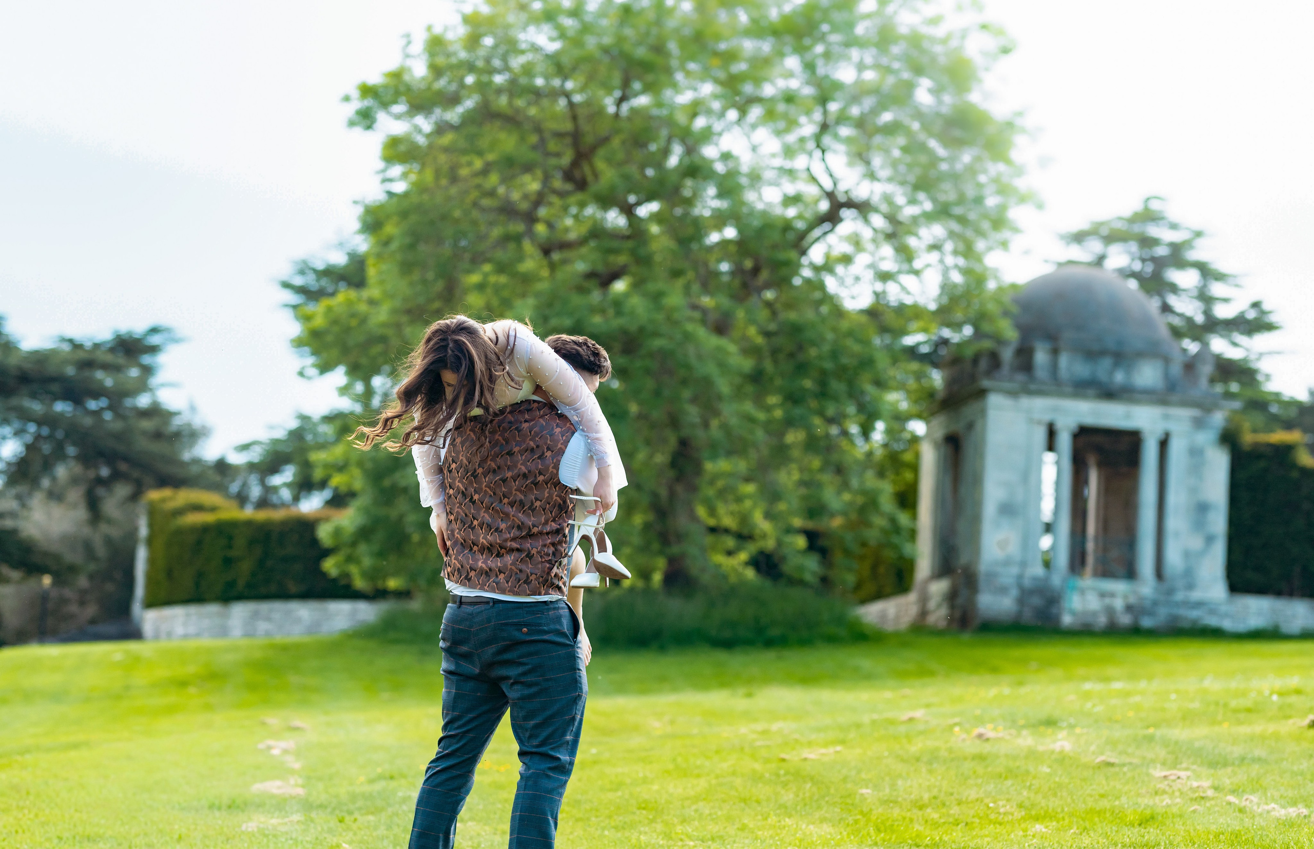 Groom lifting a young girl into the air in a joyful family moment at Luton Hoo