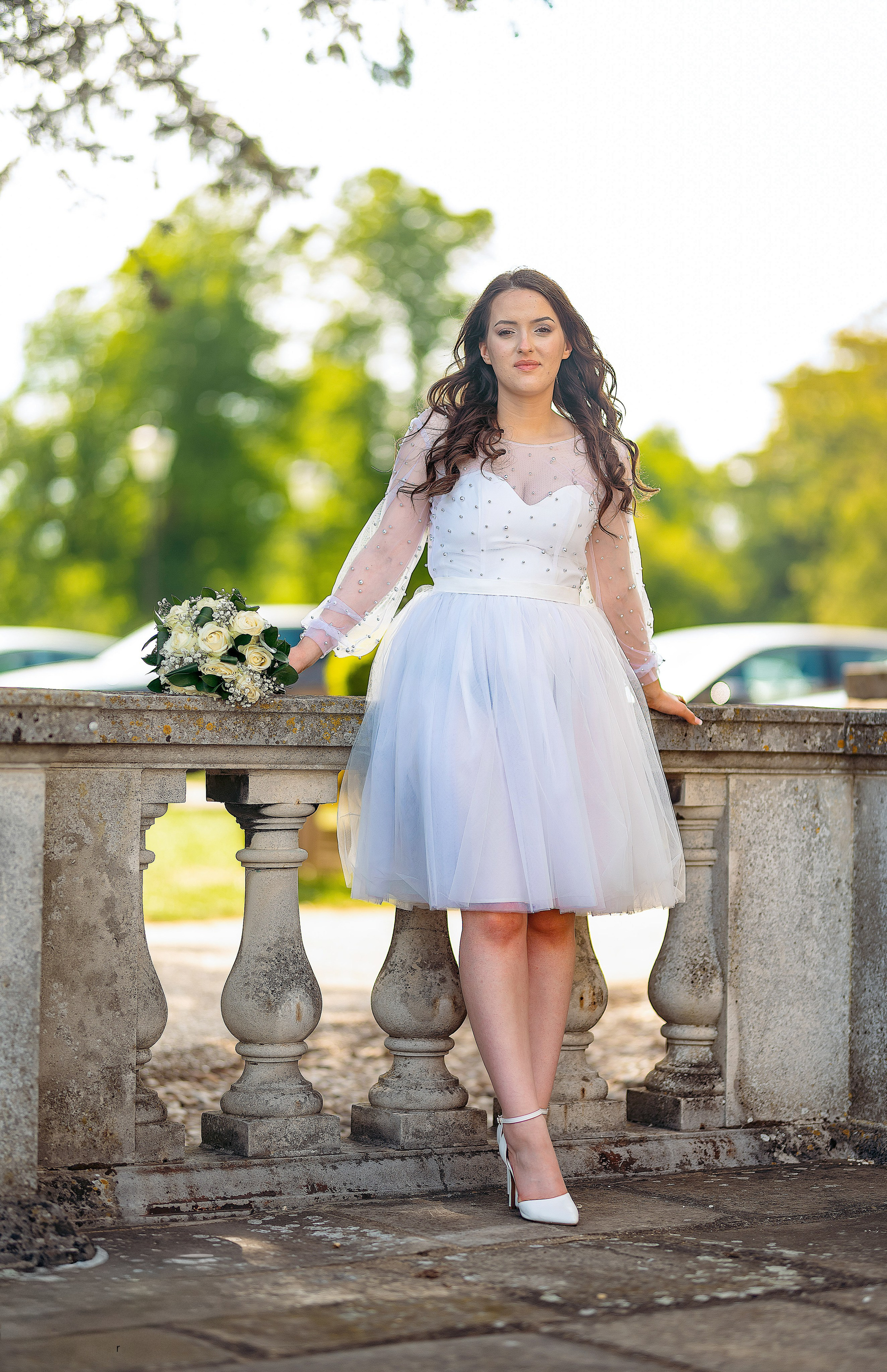 Bride and groom standing by a garden pavilion at Luton Hoo