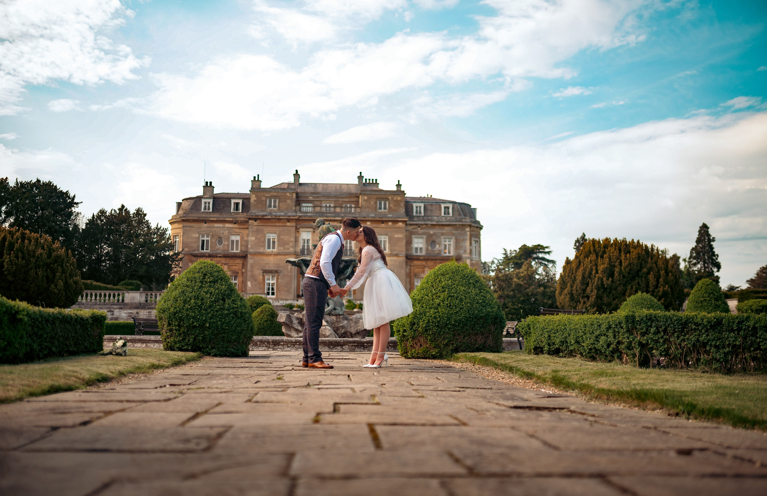 Bride and groom walking toward the grand entrance of Luton Hoo mansion, Bedfordshire