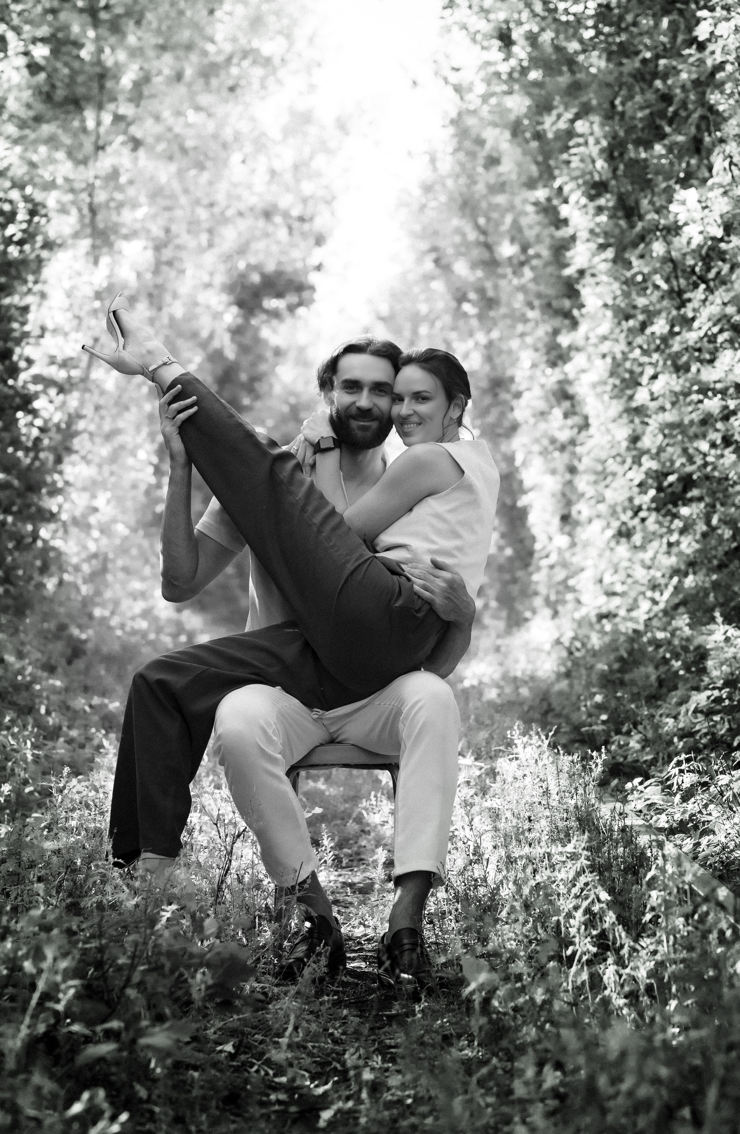 Романтический портрет пары на  стуле в  листве в лиственном тунеле, фотосессия в Анталии