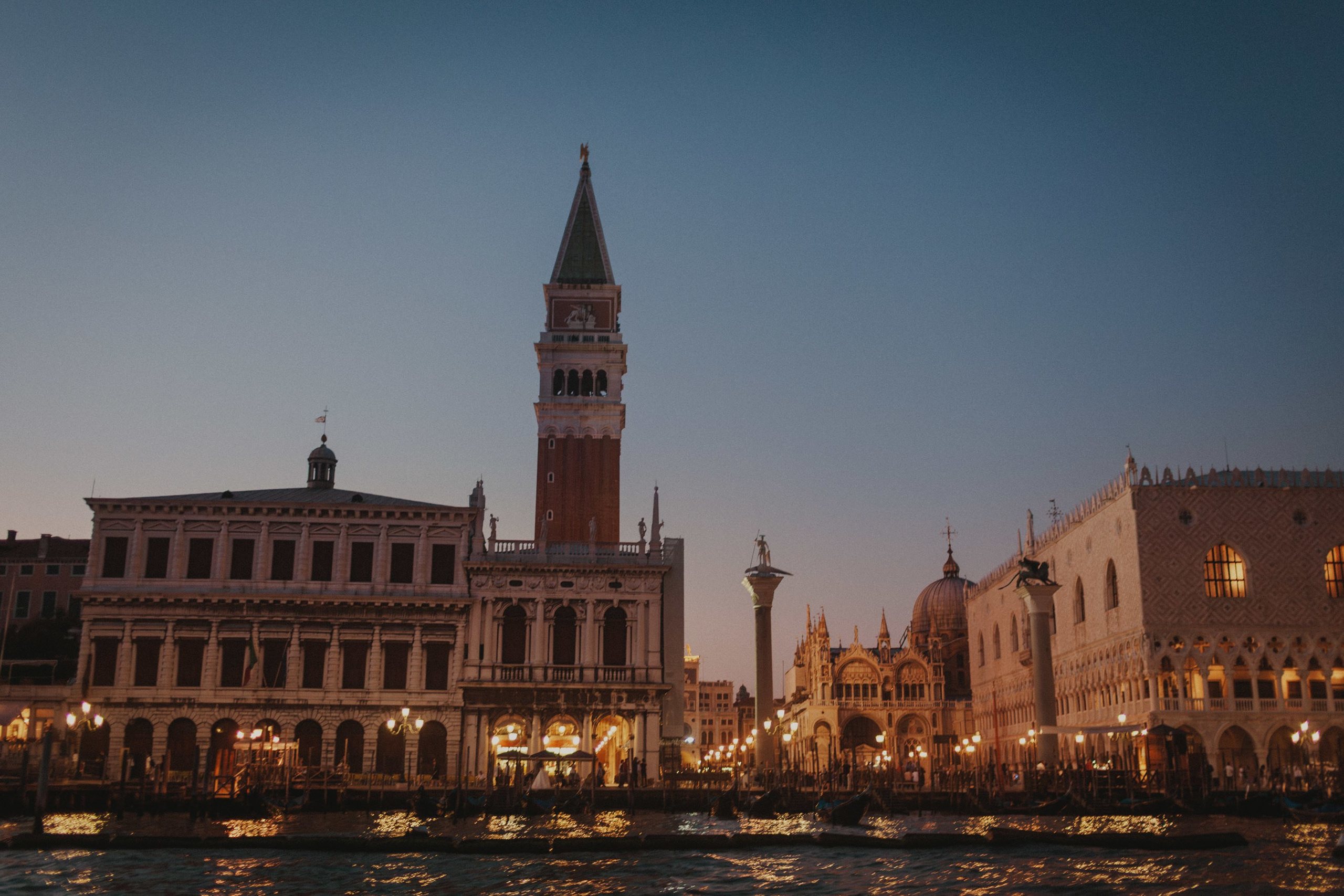 View of San Marco square and Doge's Palace from boat at dusk in Venice.